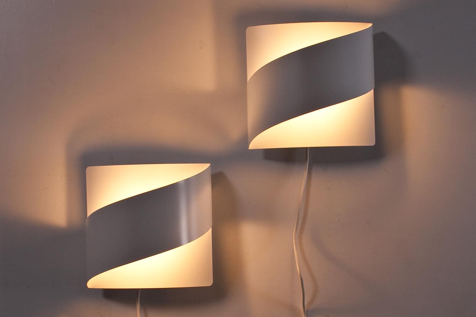 Elegant set of bent metal wall lights produced by Fagerhults Belysning AB in Sweden and designed by Peter Celsing 1960s/1970s. The items show case a beautiful light and shadow play on the wall when lighted. Label manufactured present.

Porcelain