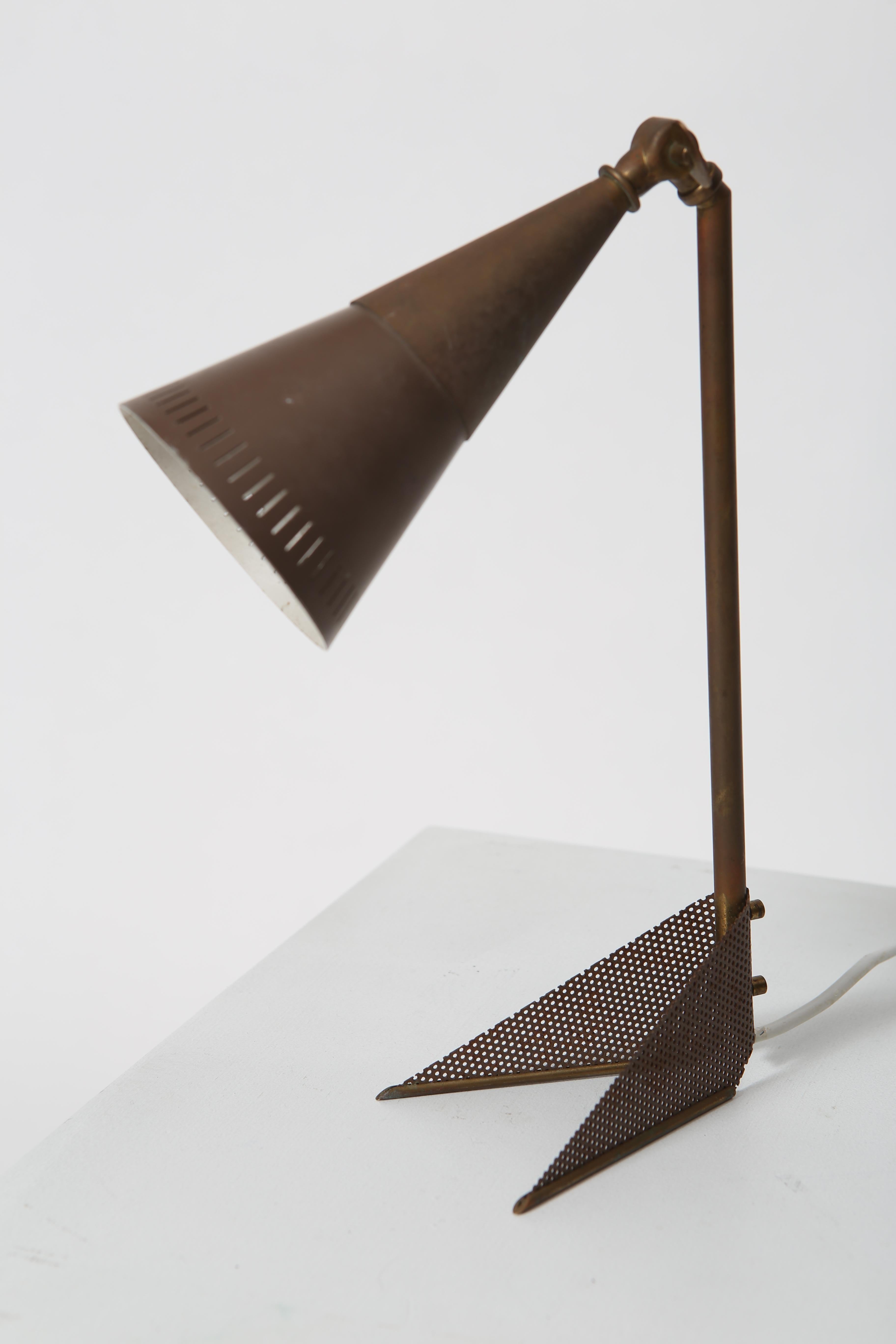 Petite perforated brass lamp with adjustable conical shade. Shade is white lacquered inside, perfectly patinated brass exterior. Wonderful little lamp, recently imported from Denmark. Unknown designer. Recommend rewiring however it is functional as