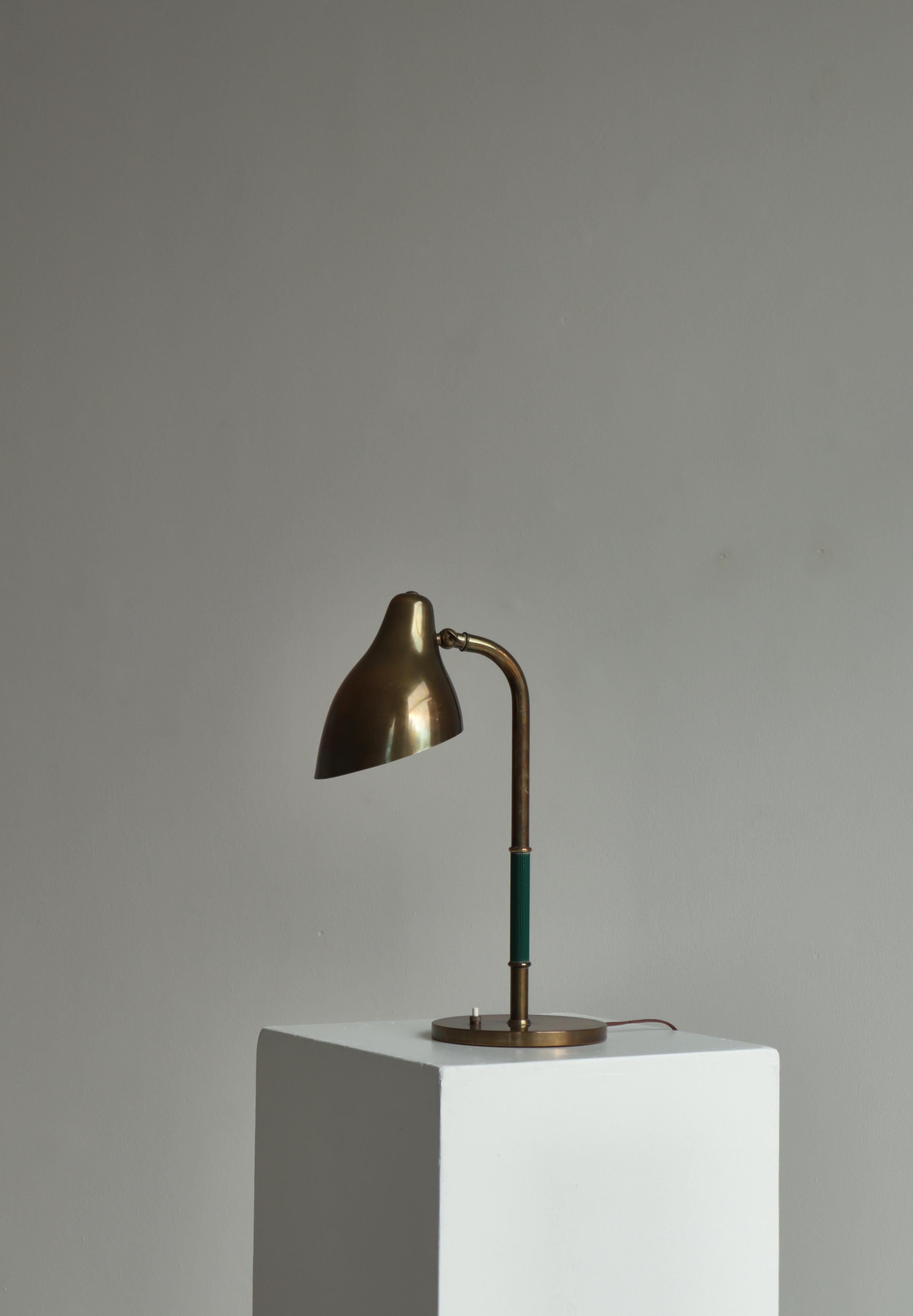 Rara lámpara de sobremesa diseñada por Vilhelm Lauritzen y fabricada por LYFA, Copenhague, en la década de 1940. Cabezal ajustable. Latón bruñido y patinado con pieza central acanalada de vinilo verde. Lacado blanco en el interior de la pantalla,.