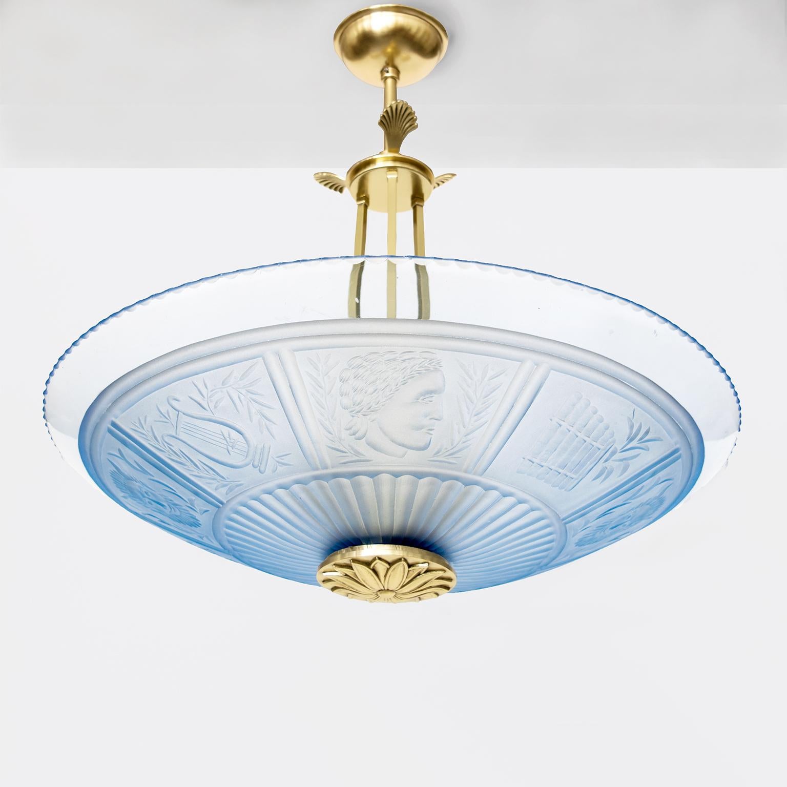 Scandinavian Modern pendant with a pale blue clear hand and acid etched glass shade which is decorated with Apollo’s head, a Pan's flute and lyre. An elegant hanging system, canopy and rosette finial are all newly polished and lacquered brass. The