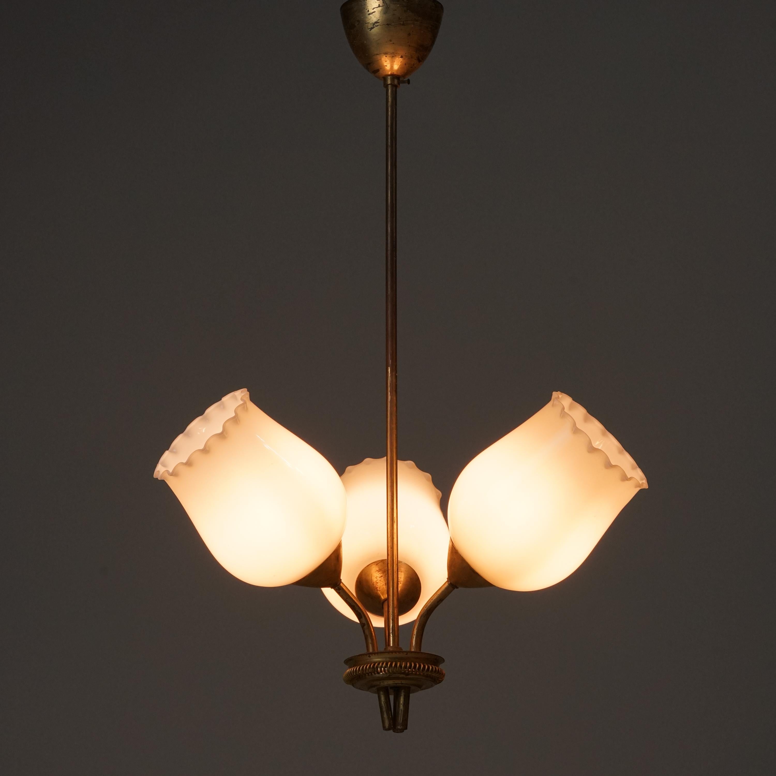 Suspension The Modern Scandinavian, fabriquée en Finlande, années 1950. Monture en laiton avec abat-jour en verre opalin. Bon état vintage, patine et usure mineure correspondant à l'âge et à l'utilisation. 
