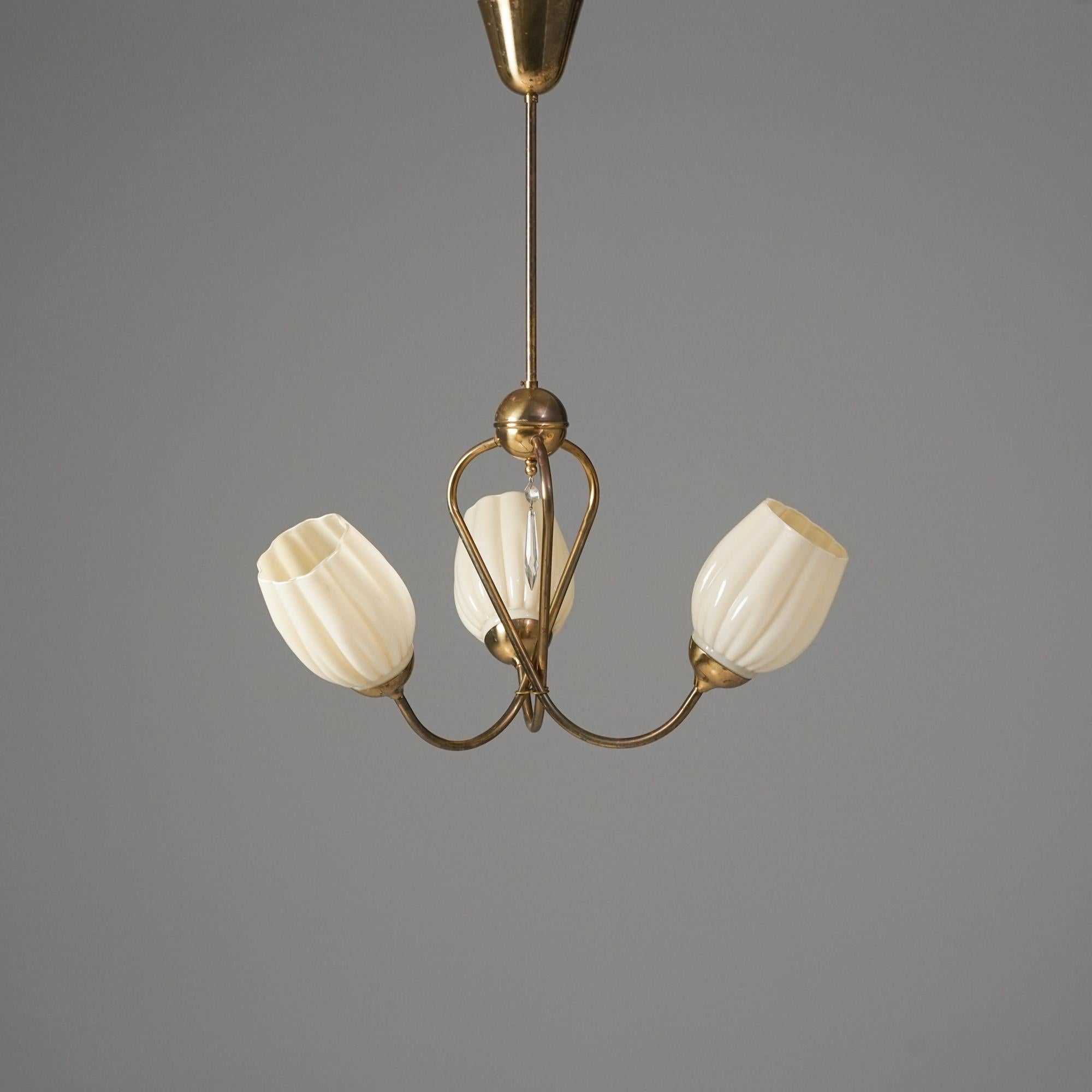 Scandinavian Modern pendant, manufactured in Finland, 1950s. Brass frame with glass shades and a crystal detail in the middle of the pendant. Good vintage condition, minor patina consistent with age and use. 