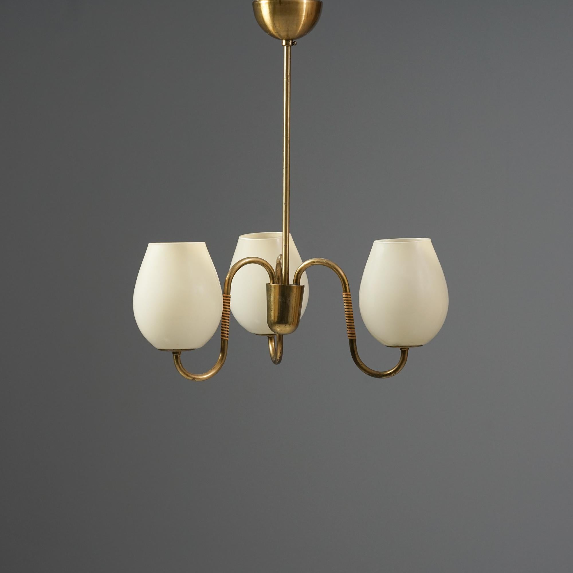 Ciondolo The Modern Scandinavian, prodotto in Finlandia negli anni '50. Struttura in ottone, dettagli in rattan, paralumi in vetro opalino. Buone condizioni vintage, lieve patina coerente con l'età e l'uso. 