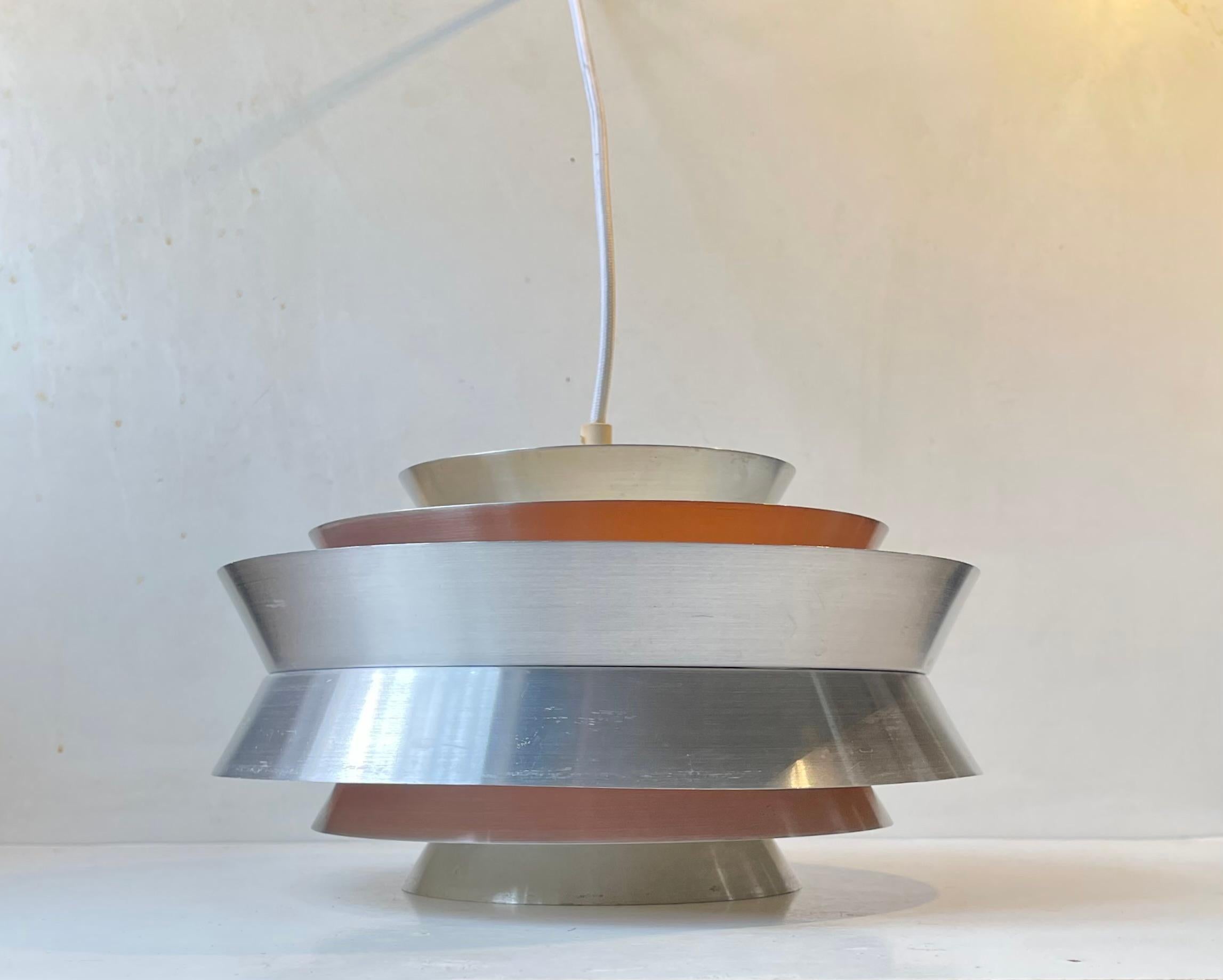 Lampe pendante en aluminium brossé appelée Trava. Conçu par Carl Thore alias Sigurd Lindquist. Fabriqué à Granhaga Metal Industri en Suède à la fin des années 1960. Il s'agit d'une construction à plusieurs niveaux et à plusieurs teintes, avec