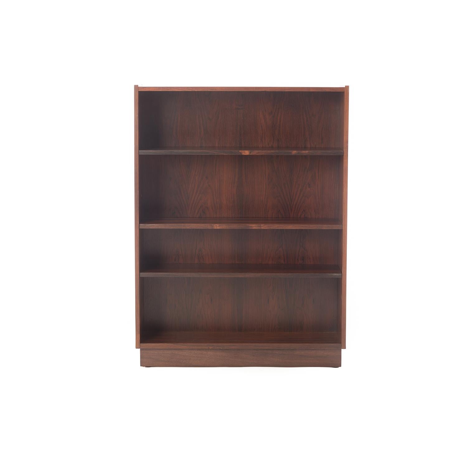 This is a lovely bookcase in a manageable (movable) size, with shelves that adjust to many settings using a hidden wire system. Plinth style base sits on the floor. Old growth rosewood with a lacquer finish. 

Professional, skilled furniture