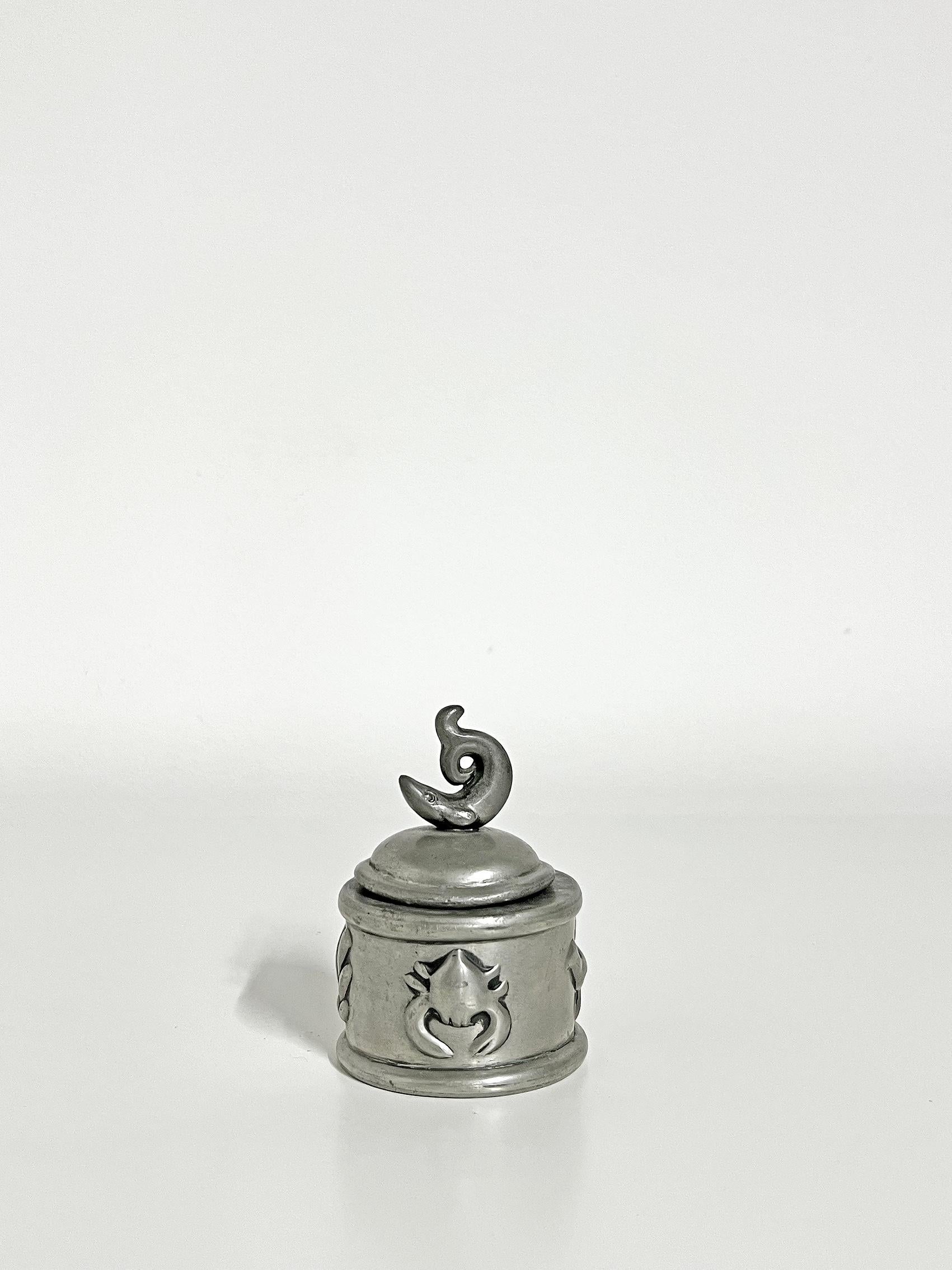 Rare pewter inkstand, Firma Svenskt Tenn, Sweden -1925.
Lid in the shape of a fish, relief decoration along the sides.
The insert in glass is missing. 
Wear and patina consistent with age and use. The lid is slightly misshaped, as seen on the first