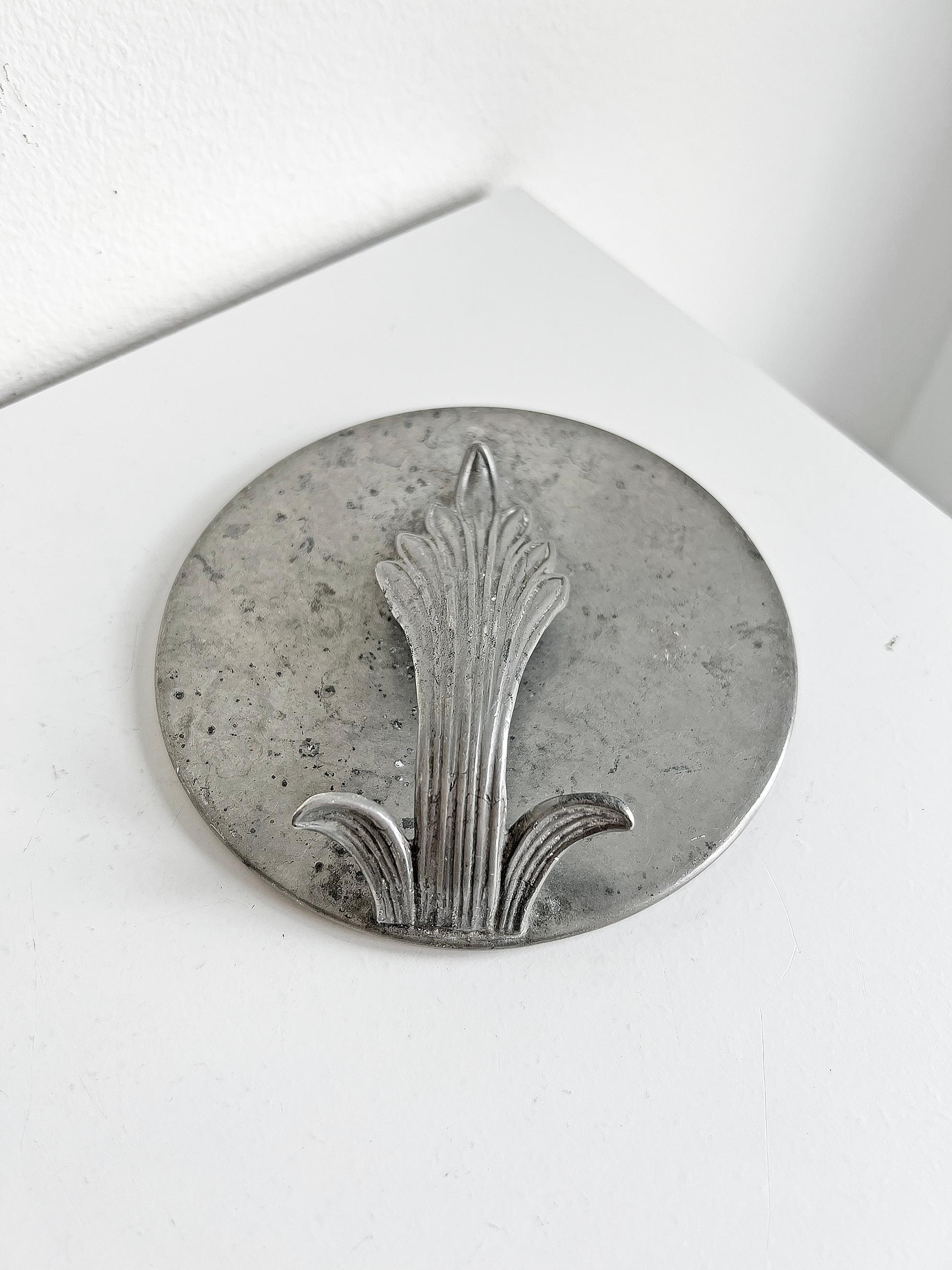 Scandinavian modern pewter vanity mirror with a decorative handle, Sweden ca 1930's. 
Unknown designer and maker.
Marks and scratches. Original mirror with slight fading & a small chip (as seen on the last picture). 
The mirror is a bit loose in
