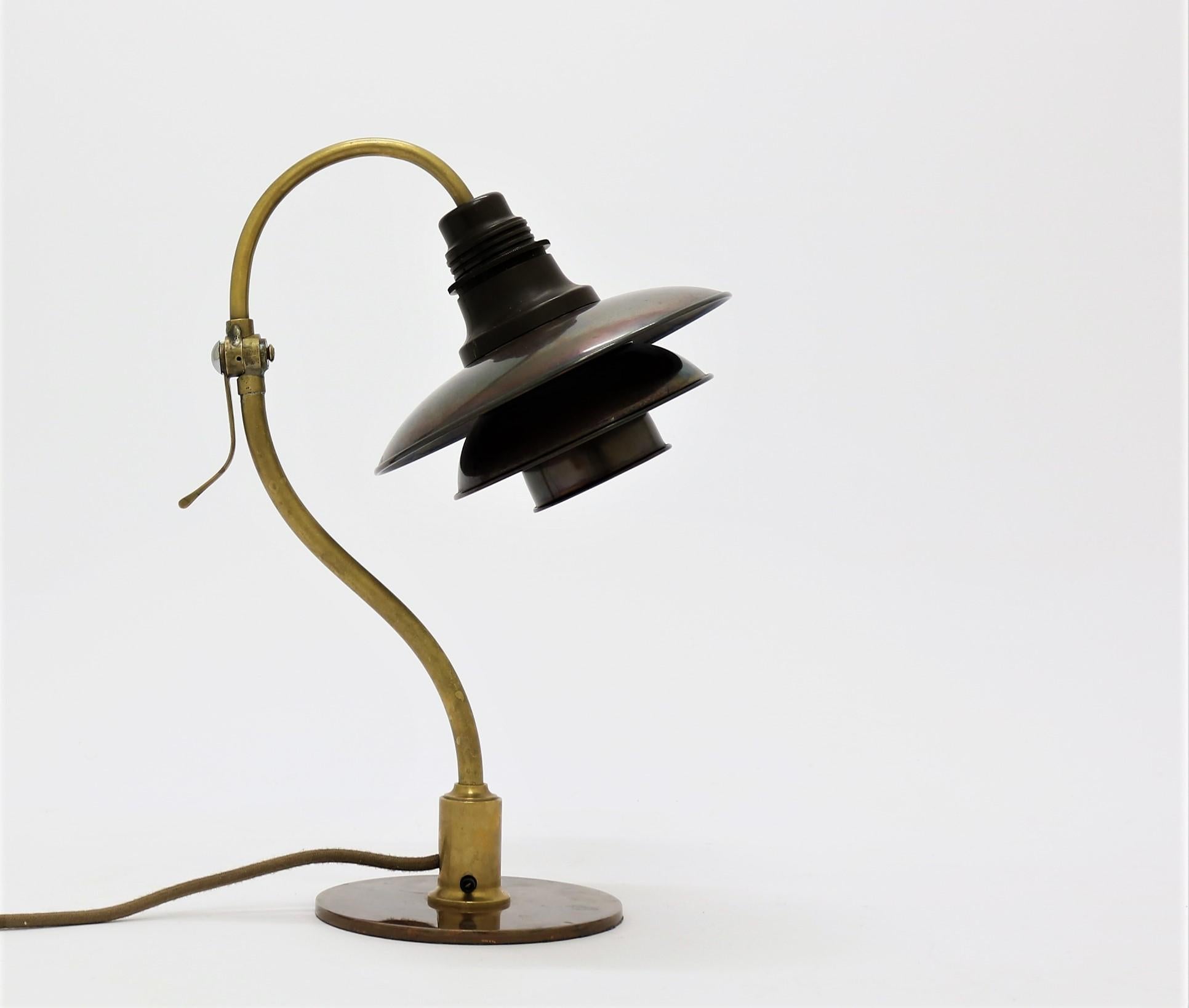Rare and stunning desk lamp by iconic Danish designer Poul Henningsen from the 1930s. The base is made from beautifully patinated brass and copper and the 2/2 shades from dark and rich patinated copper. The lamp has never been restored and all parts
