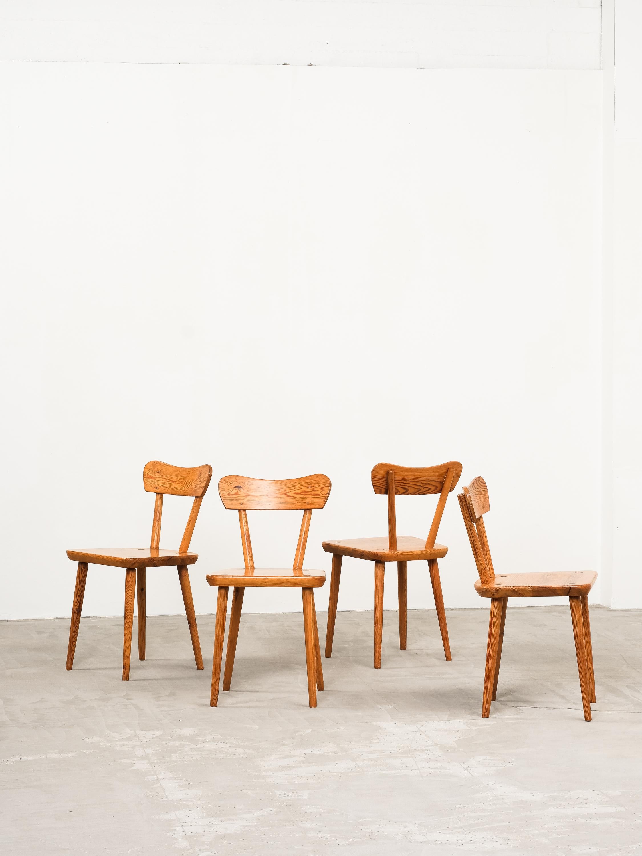 Scandinavian modern set of 4 pine dining chairs. The chairs are made in solid Swedish pine around 1970s. The chairs follow the Scandinavian modern ideals with the minimalistic design and high functionality combined with an attention to detail and