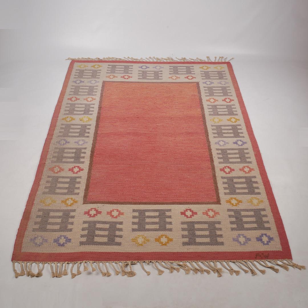 Un bellissimo tappeto vintage in lana svedese a tessitura piatta di Alice Wallebäck degli anni '60, con le sue iniziali tessute (AW) nell'angolo inferiore. Questo tappeto Scandinavian Modern Rölakan presenta un disegno floreale geometrico in due