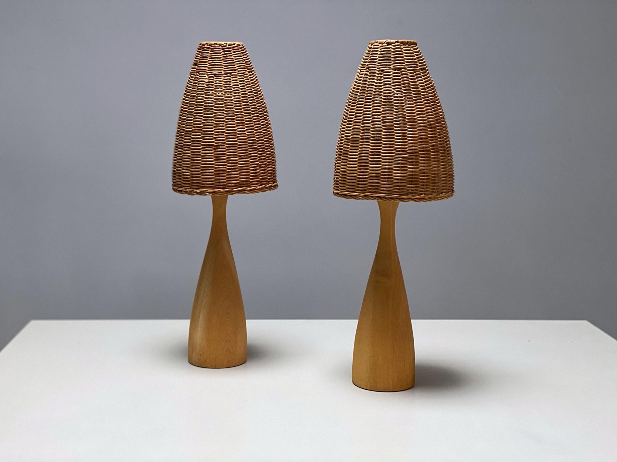 Pair of very elegant Scandinavian Modern table lamps manufactured in 1970s, Sweden. The lamps are made of solid walnut with rattan shades that provide a smooth and wonderful light. The lamps are in very good condition, fully working and tested. One
