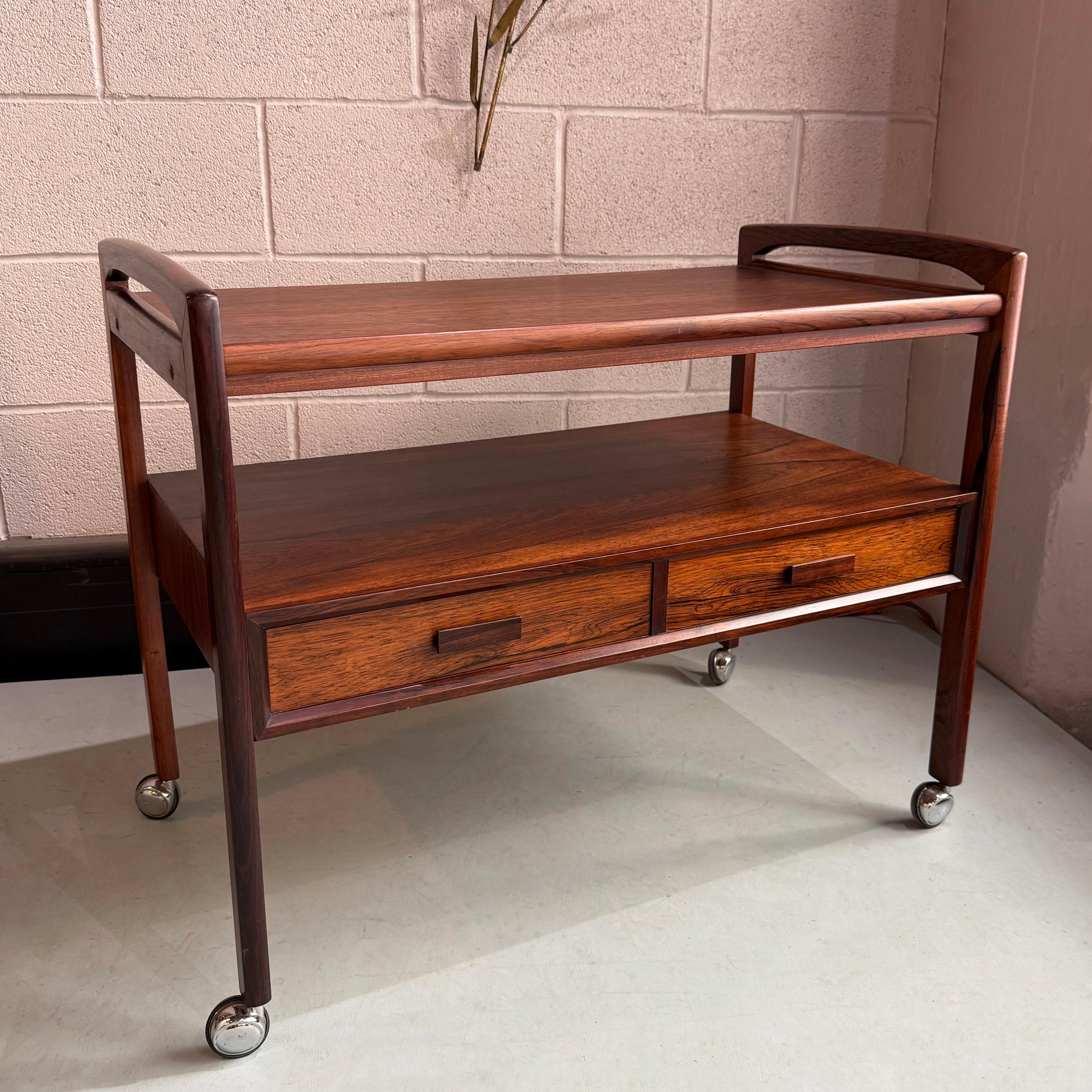 Questo carrello bar moderno danese in legno di palissandro è stato prodotto da Arrebo Mobler, in Danimarca, intorno agli anni Sessanta. Questo elegante carrello presenta la quintessenza del design The Modern Scandinavian, come le linee pulite e
