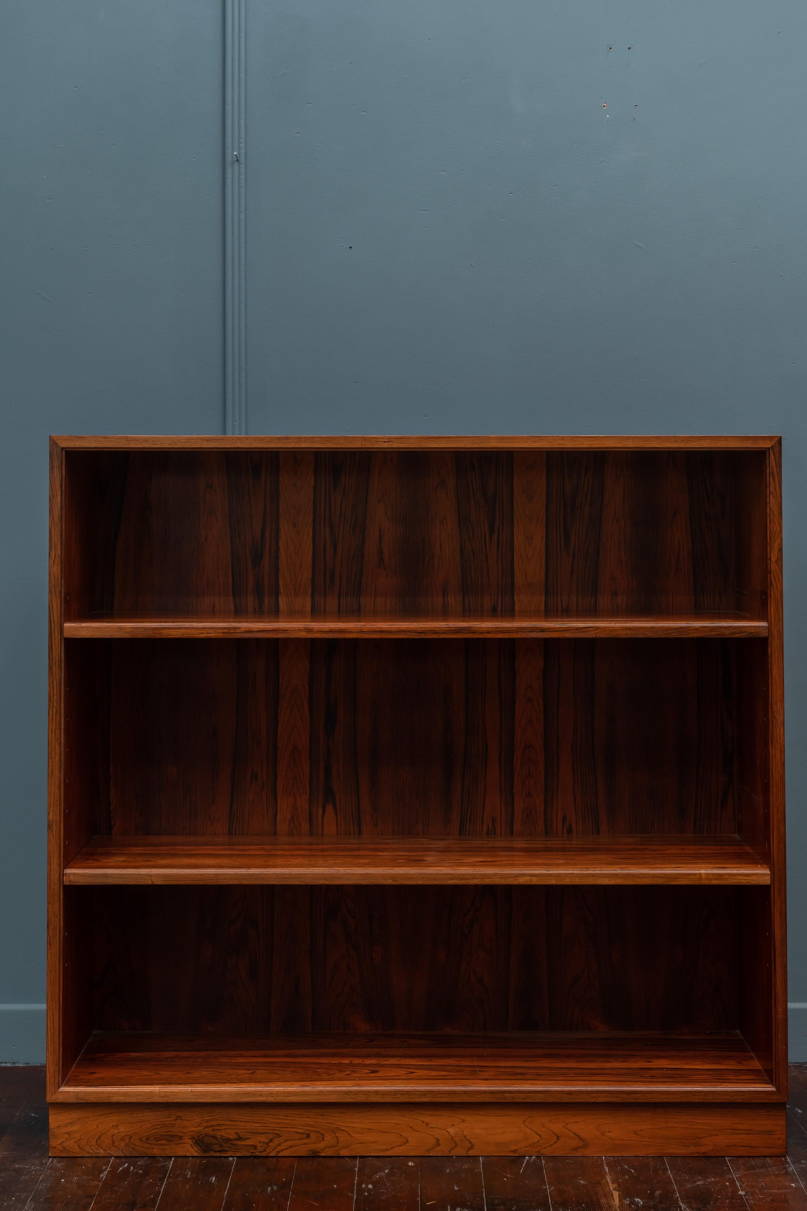 Scandinavian modern rosewood bookcase with three adjustable shelves by Willy Beck, Denmark. Made with book dramatic book matched veneer and attention to detail with a finished back, very good original condition, labeled.