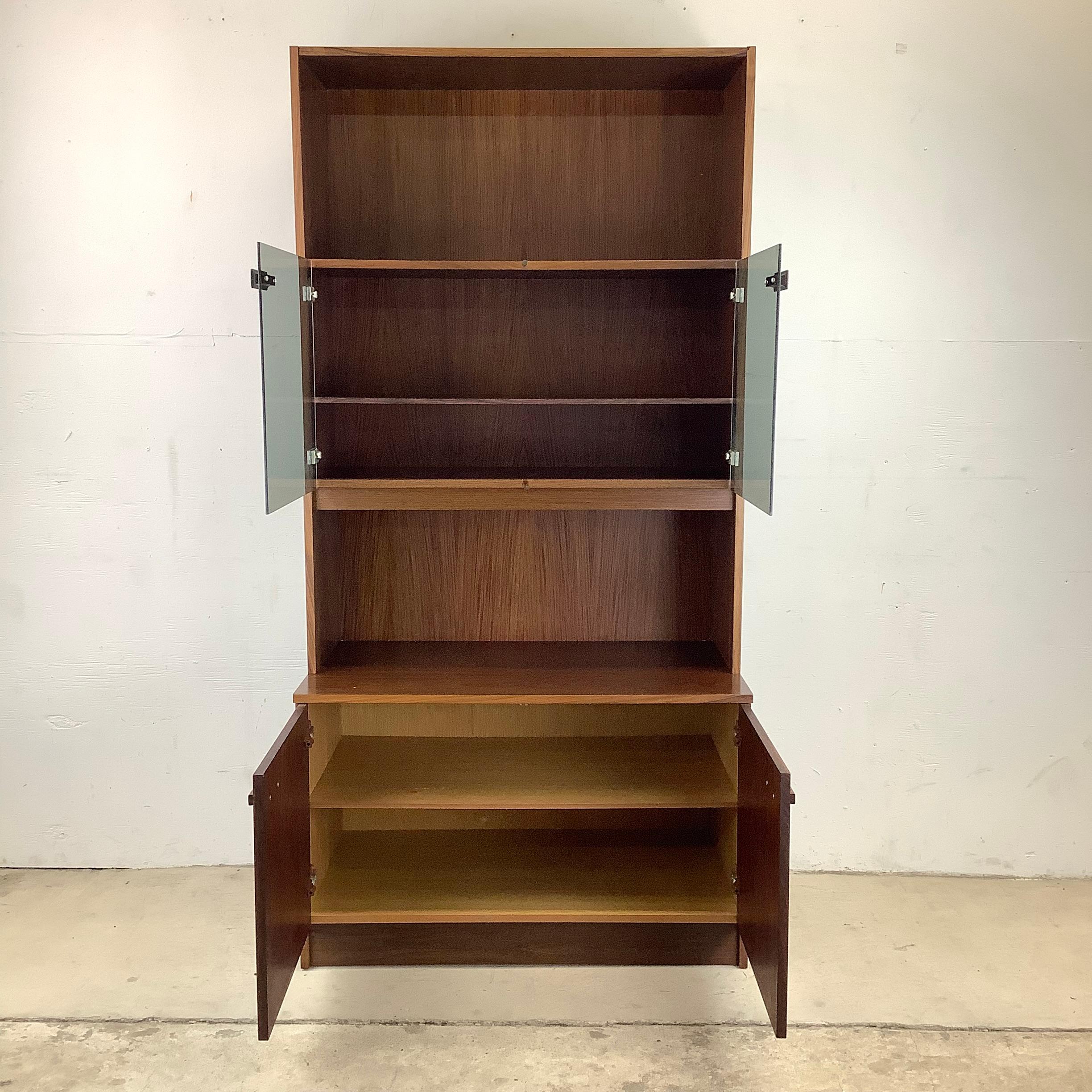 This stylish Scandinavian Modern rosewood bookshelf with smoked glass cabinet and lower storage cupboard makes a unique addition to any interior. The perfect Size for a space saving bar cabinet or for a mixture of display and storage in home or