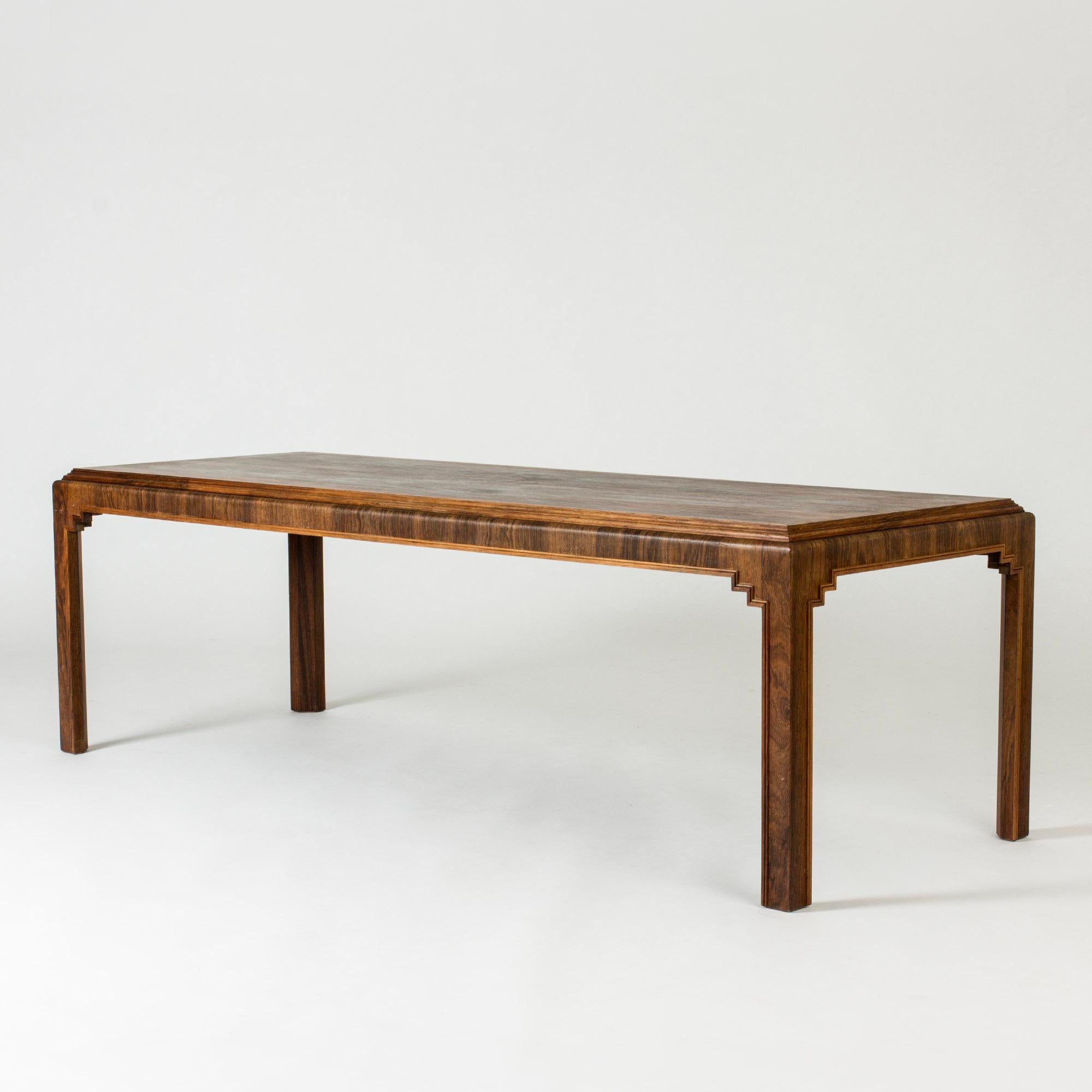 Elegant rosewood coffee table, made in Sweden in the 1930s. Rosewood veneer laid in contrasting directions on the table top and on the side rim. Striking graphic ornaments in the joinery between legs and table top.