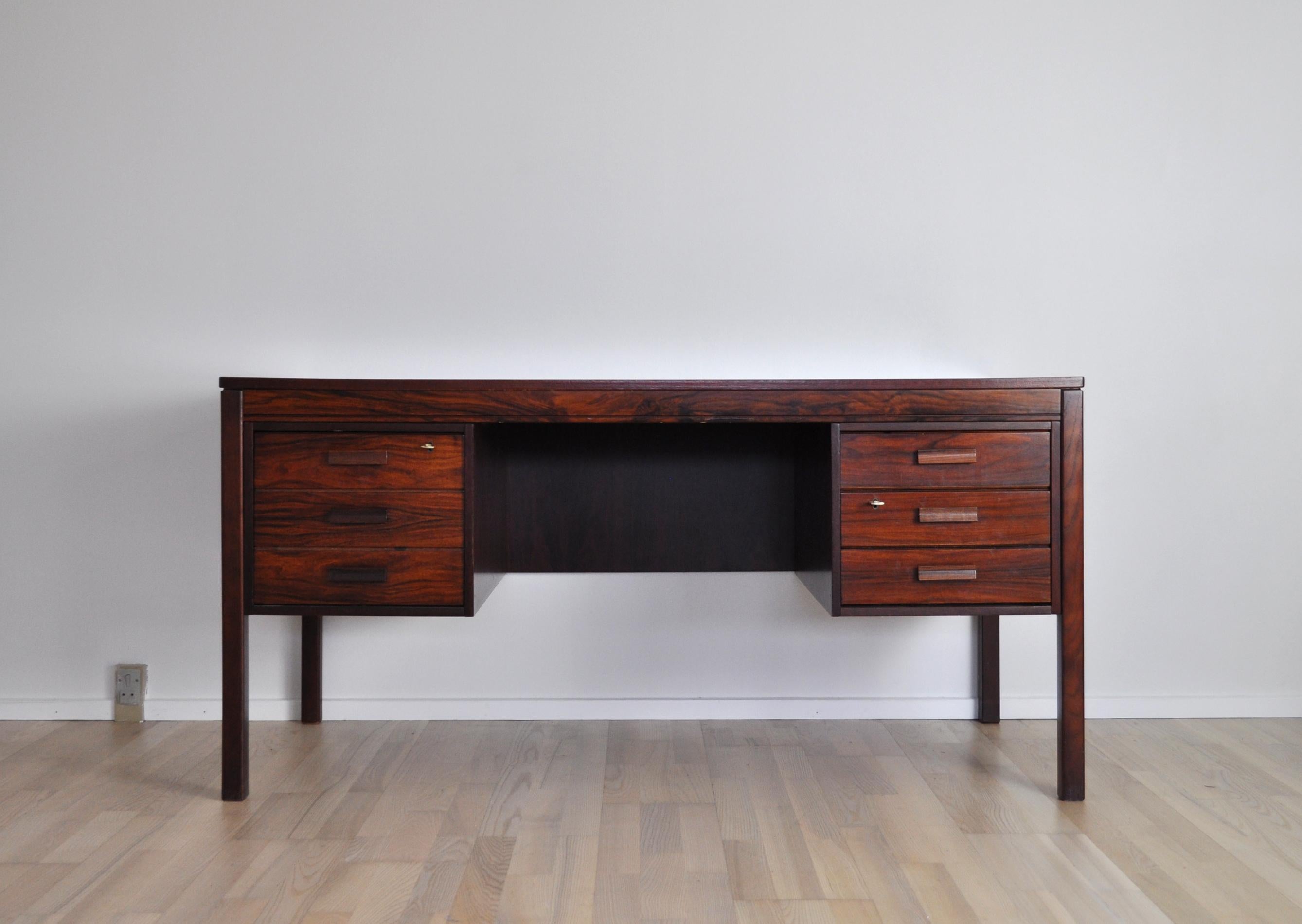 Rosewood desk with a square design marquetry top by PS Heggen of Norway, late 1960s. The desk has three drawers on the right and one large on the left. Two keys including. Labeled by maker.
     