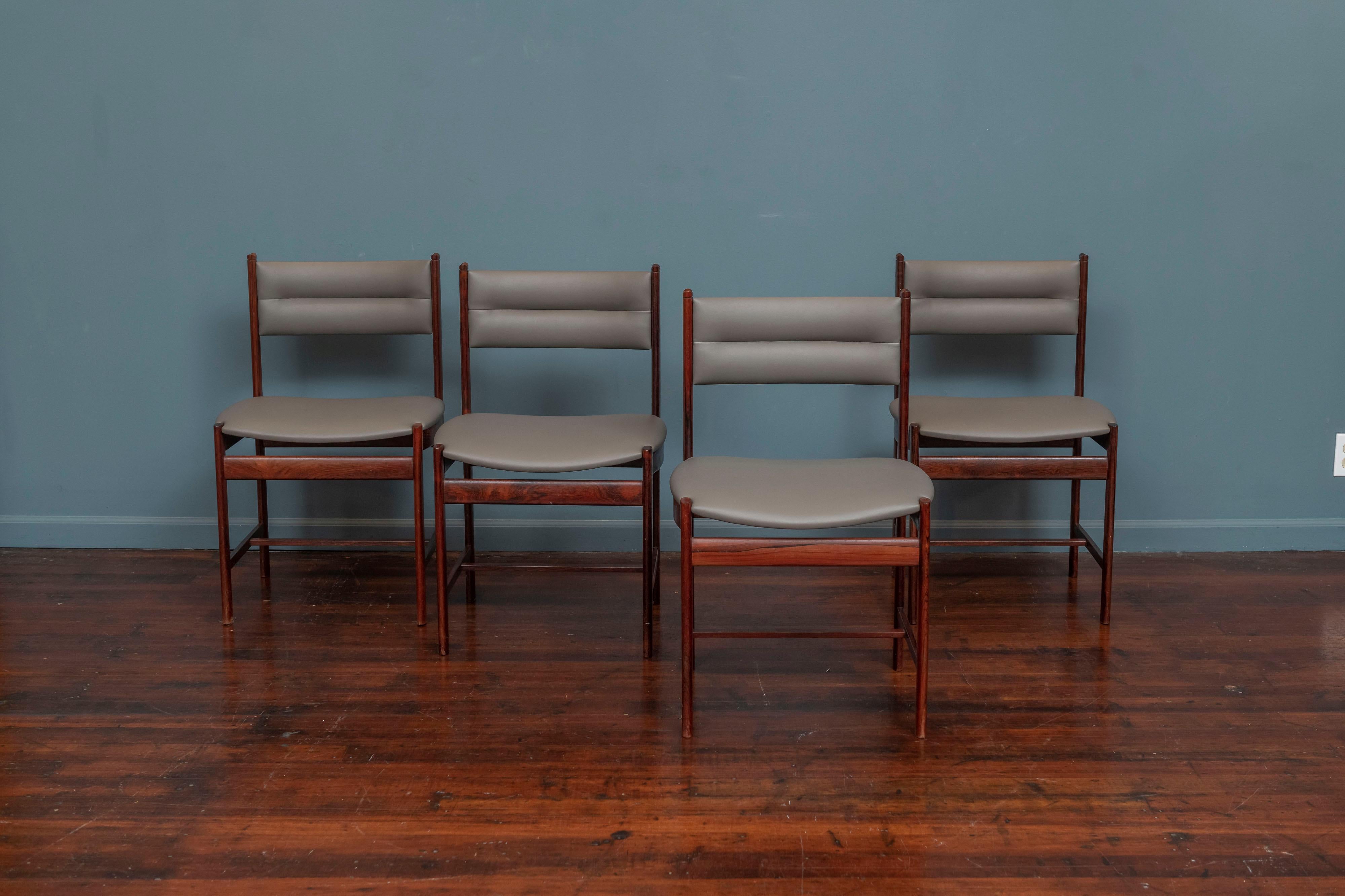 Scandinavian modern rosewood set of four dining chairs, Denmark.
 Newly upholstered in a putty gray vinyl upholstery with original finish solid rosewood frames.