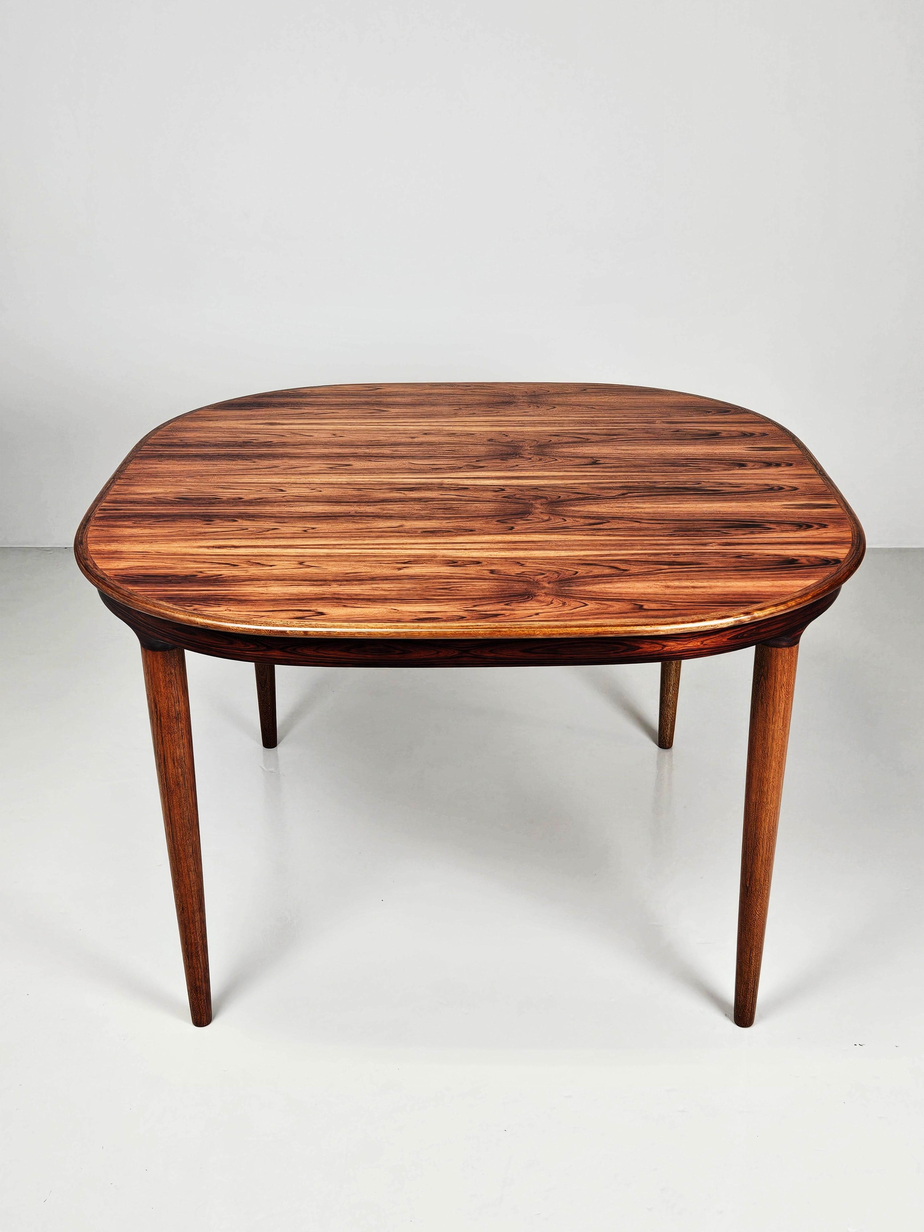 Superbe table de salle à manger d'un designer inconnu. Produit au Danemark dans les années 1960. 

Fabriqué en bois de rose de haute qualité. 

Deux feuilles extensibles de 50 cm chacune. La longueur maximale est de 215 cm. 