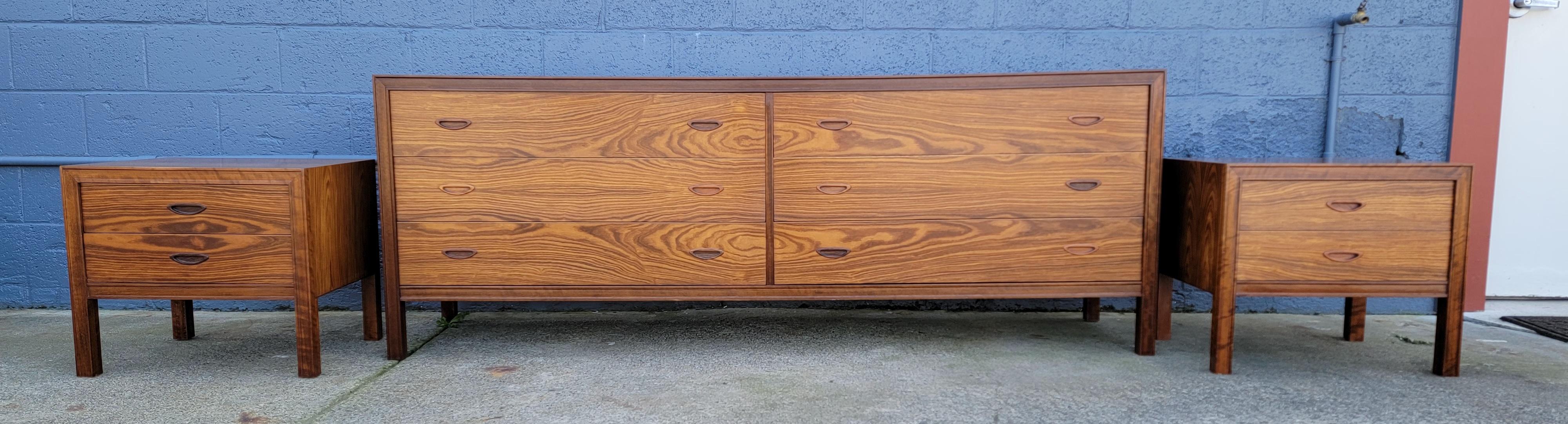 Fine Scandinavian Modern rosewood low dresser and matching nightstands. A three piece set. Extraordinary book matched wood grain with amazing figuring and contrasting color striations. Absolutely beautiful. Excellent original finish and condition.