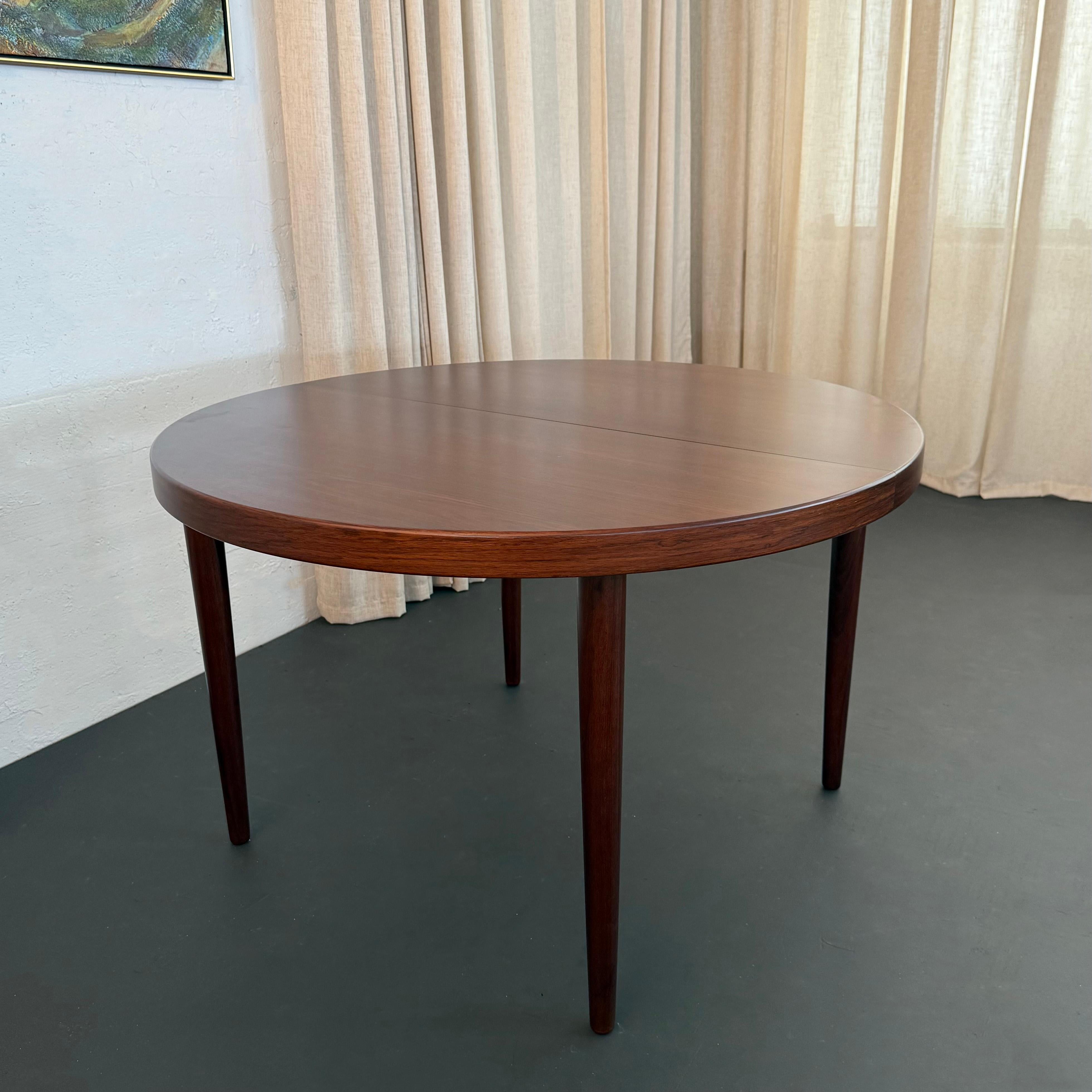 Cette table de salle à manger à rallonge en palissandre, à la fois simple et élégante, a été conçue par Kai Kristiansen pour les fabricants de meubles Skovmand et Andersen vers les années 1950. Cette table de salle à manger ronde est un exemple
