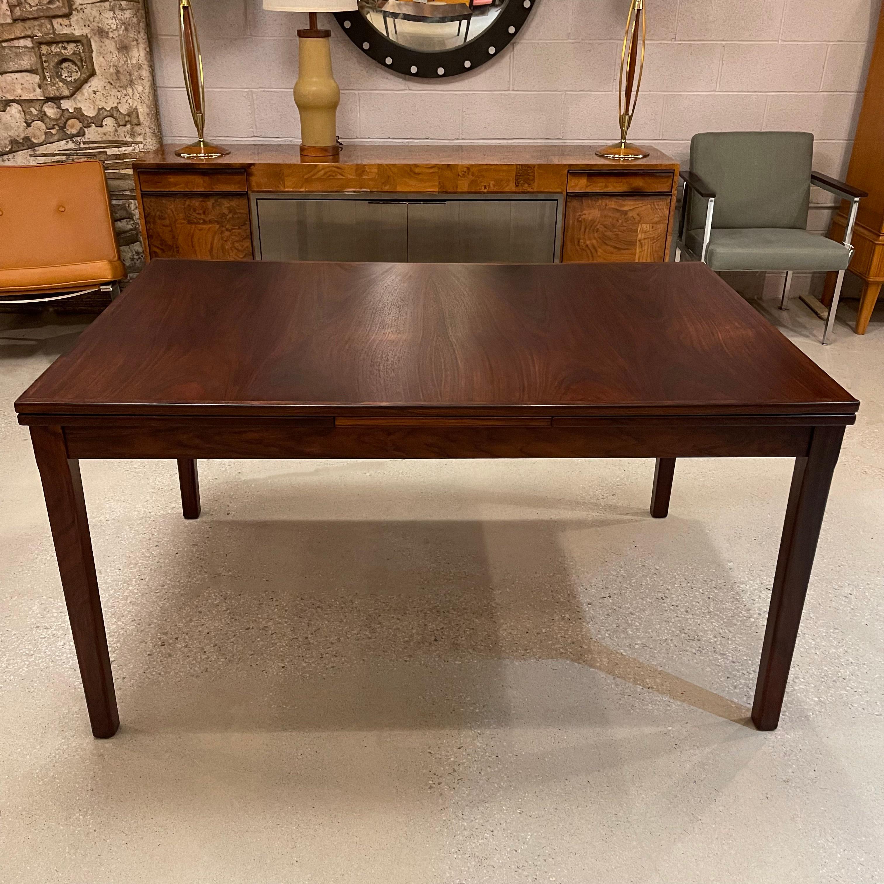 Stunning, Scandinavian modern, rosewood extension dining table features two 20 inch leaves that are stored underneath the table to extend from 54 - 94 inches seating 8-10 guests.