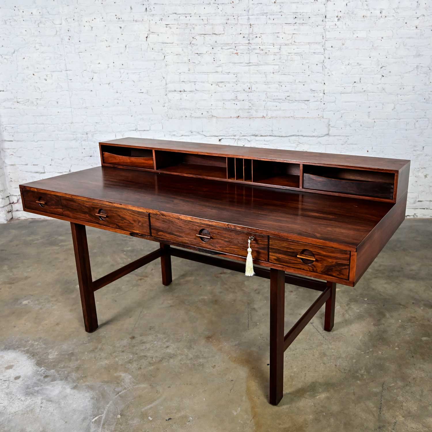 Phenomenal vintage Scandinavian Modern rosewood flip top executive partners desk by Peter Lovig Nielsen for Lovig Dansk Designs. Comprised of a rosewood frame and drawer handles, rounded butterfly hinges, and brass lock mechanism with original key.