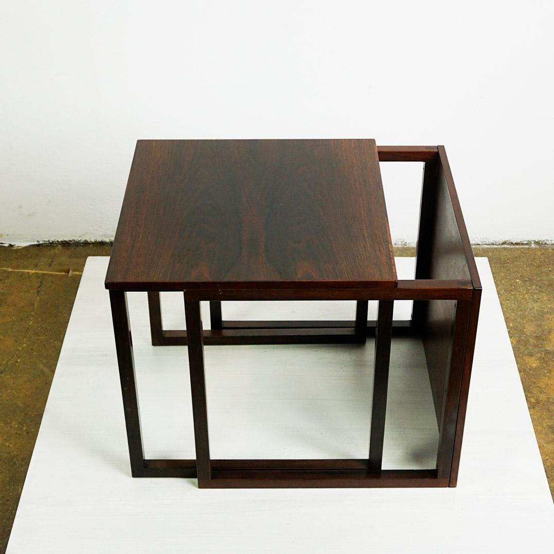 Cette superbe table gigogne en forme de cube a été conçue par Kai Kristiansen pour Vildbjerg Møbelfabrik, au Danemark, vers les années 1960. Il  caractéristiques  un ensemble de trois tables carrées en bois de rose naturel avec des détails de