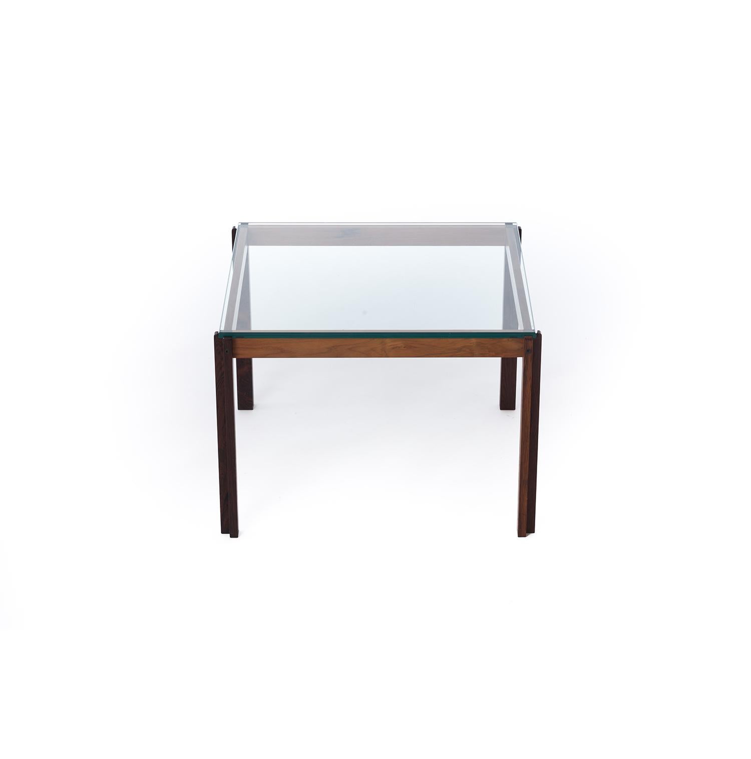 This elegant side table is crafted from beautifully figured rosewood with an inset glass top. It is a Danish modern original piece however it could easily blend in an international style environment with it's light and airy profile coupled with the