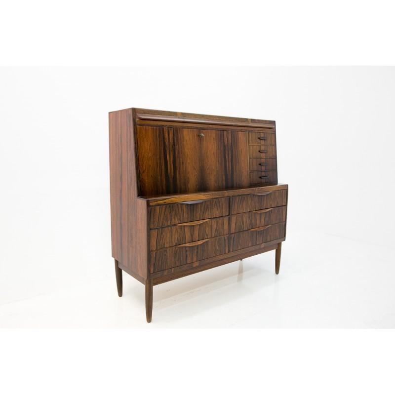 Scandinavian modern, secretary cabinet by Ib Kofod-Larsen features a rare, exotically grained rosewood finish with beautifully sculpted drawer handles and tapered legs. The top front opens into a desk space revealing a variety of drawers, shelves