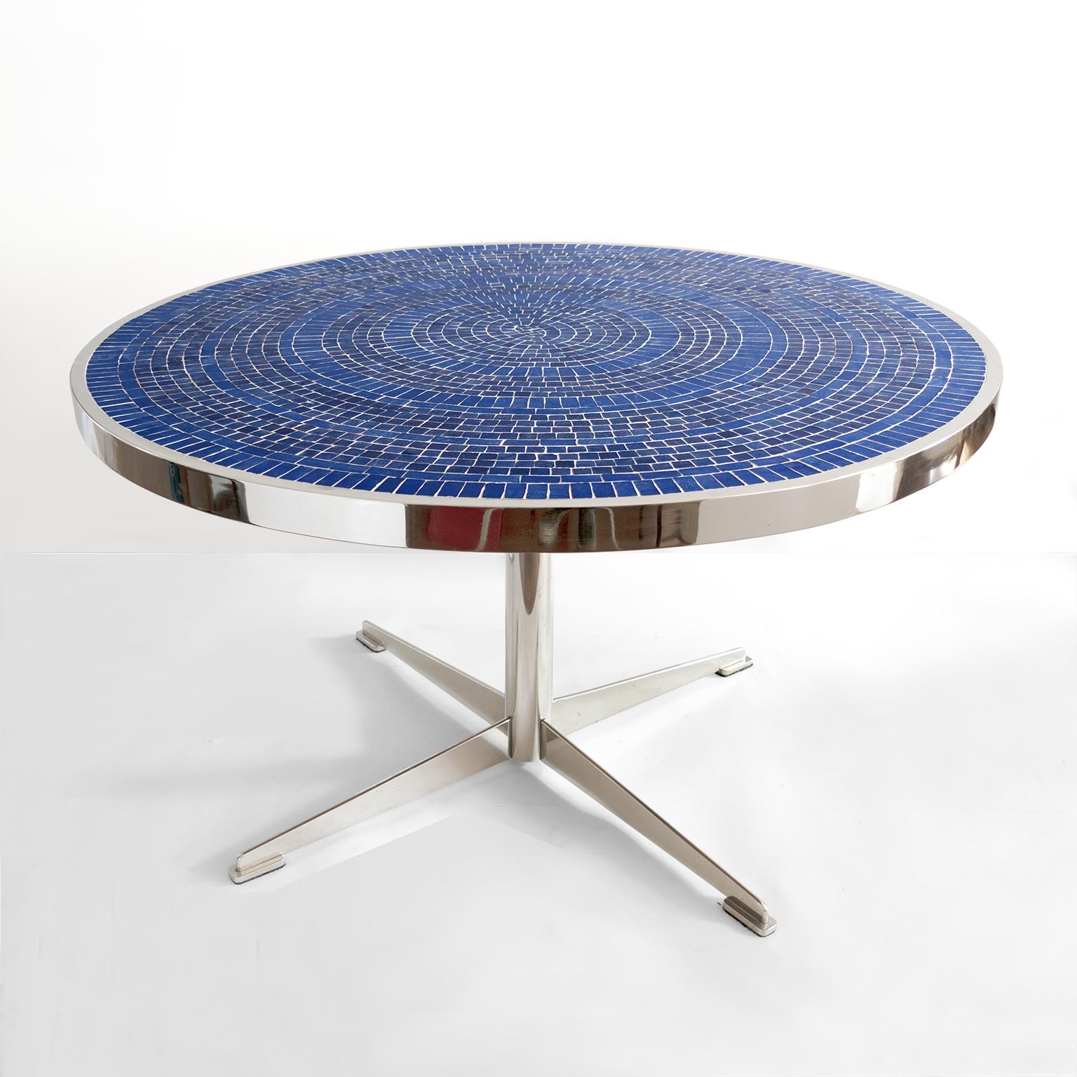 Table de salle à manger ronde The Modern Scandinavian avec plateau en mosaïque de verre bleu cobalt.  un motif cible. La colonne centrale de la table est soutenue par quatre gracieux pieds en forme de coin. Le cadre en acier poli est très