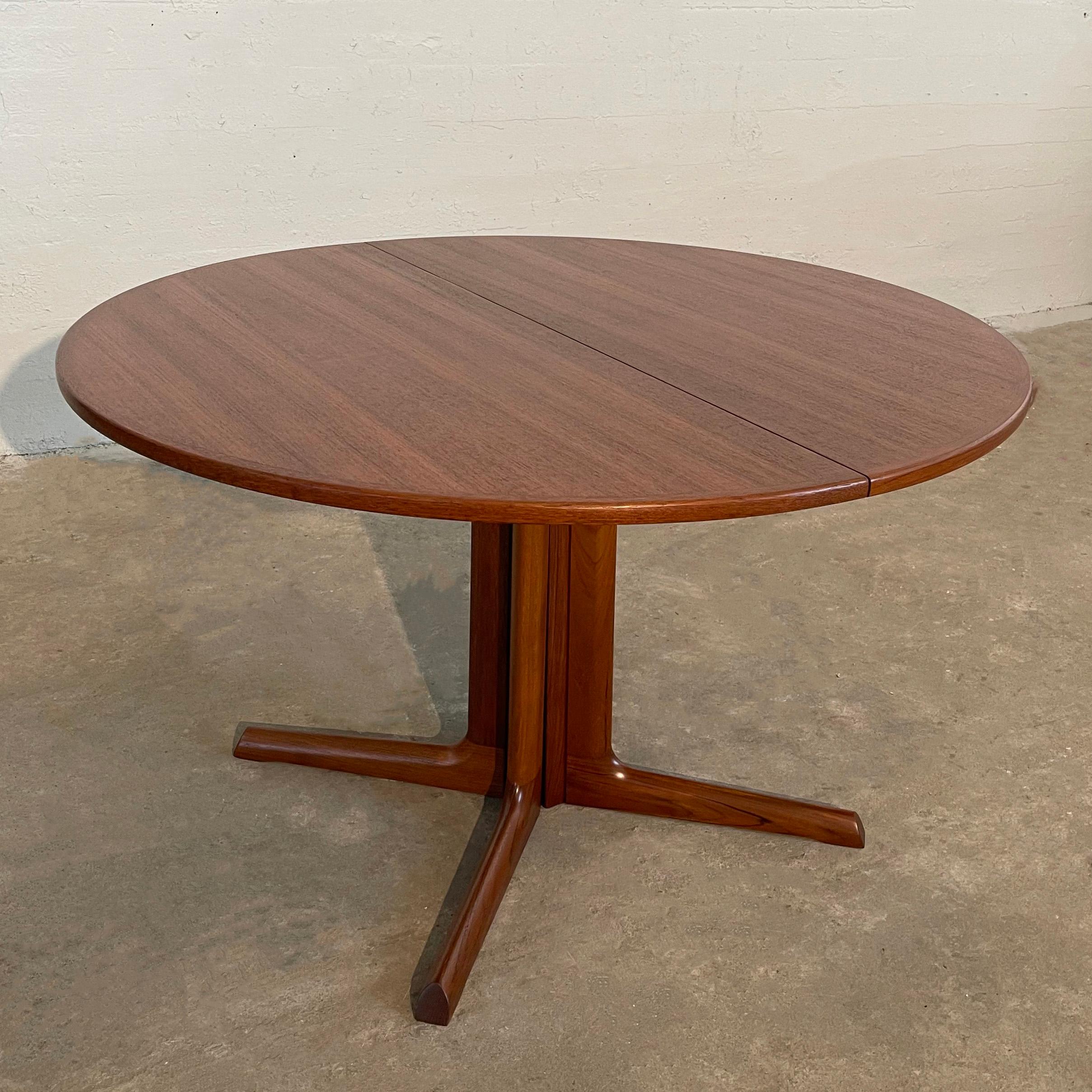 Scandinavian modern, teak dining table features a round top with edged border on a sculptural 4 prong pedestal base. The table seats 4 but extends to a 67 inch wide oval with a separate 19 inch leaf to accommodate 6 people comfortably.  Shown with