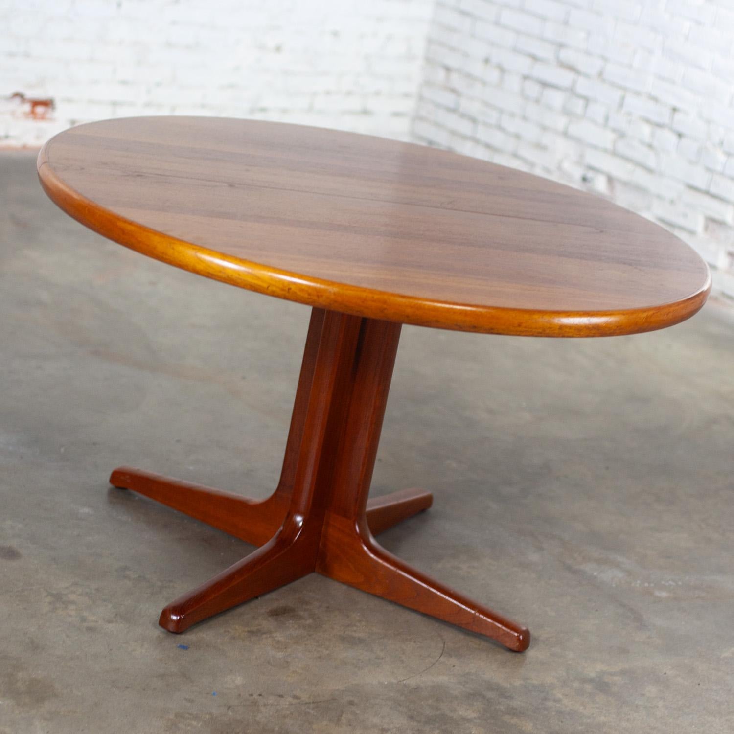 Handsome Mid-20th Century Scandinavian Modern round to oval teak expanding dining table with 2 leaves Attributed to Gudme Mobelfabrik, made in Denmark. This piece has been attributed based upon archived research including online sources, vintage