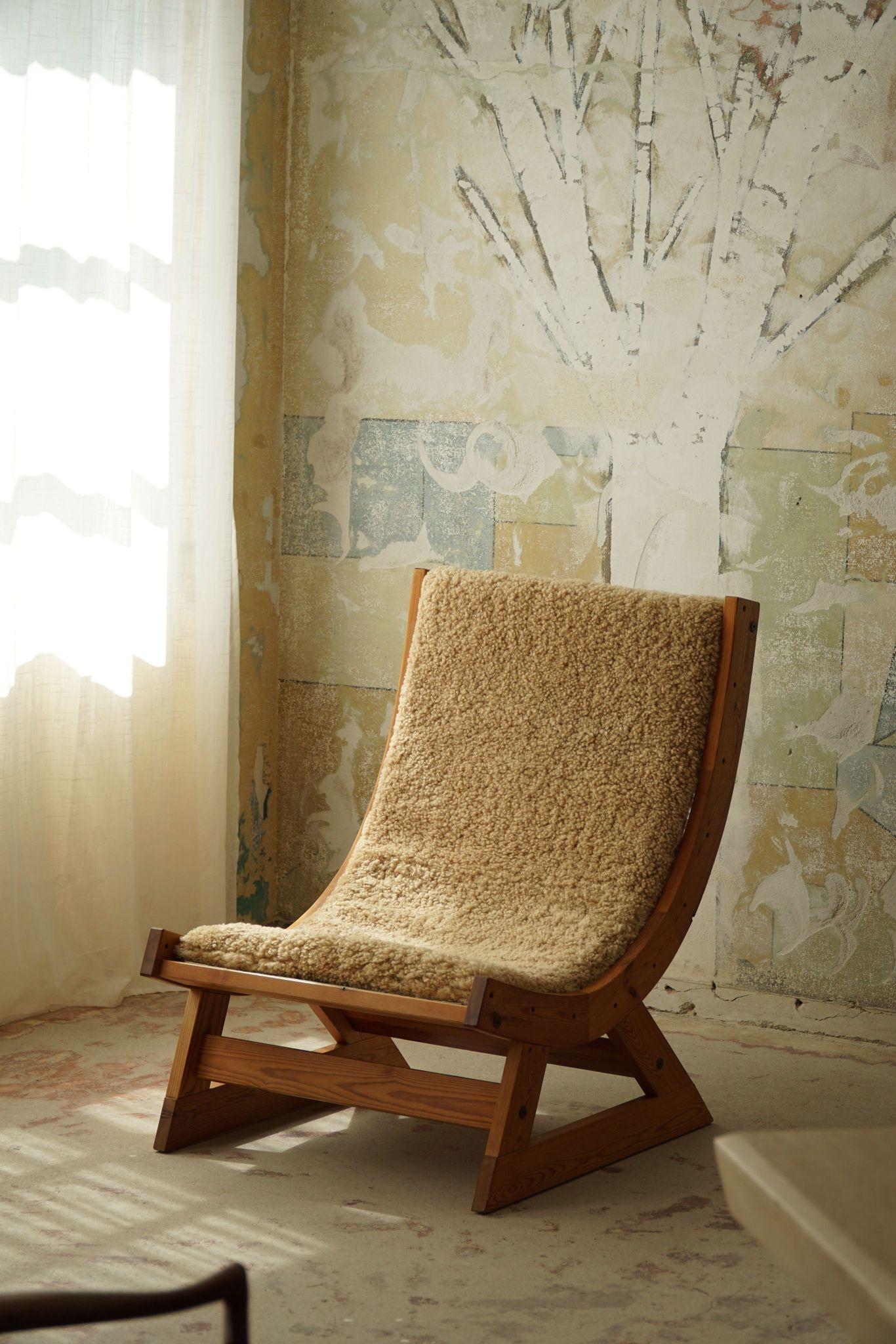 A true Scandinavian gem. This chair features a sturdy pine frame, highlighting the natural beauty of the wood. The seat and backrest are made of durable canvas, offering comfortable support, while a cushion of plush lambswool adds a touch of luxury.