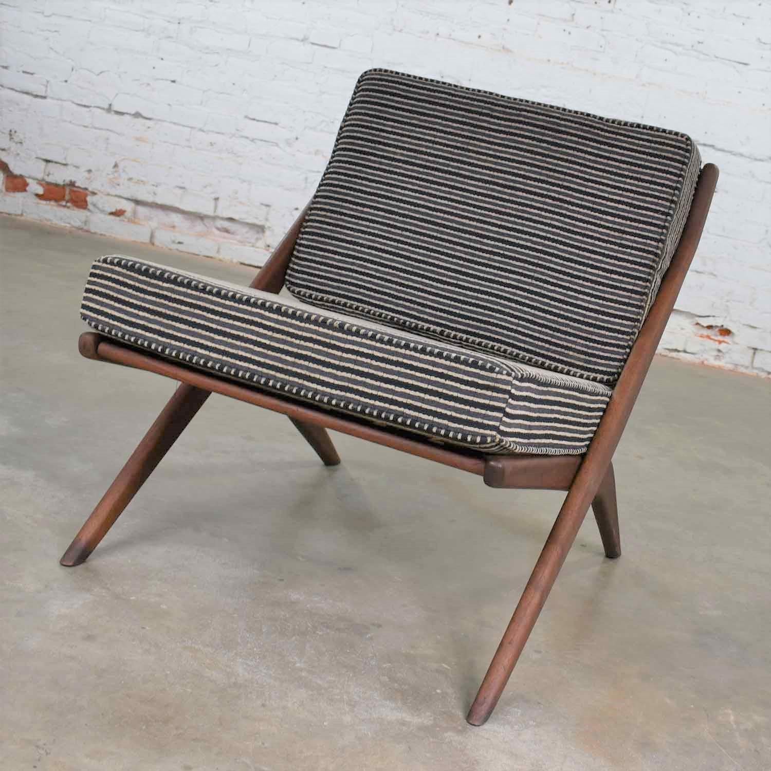 Handsome and iconic Scandinavian Modern Scissor lounge chair designed by Folke Ohlsson for DUX. It is in wonderful vintage condition. The wood frame has been restored; however, there may still be small signs of age. We did have to fill some rather