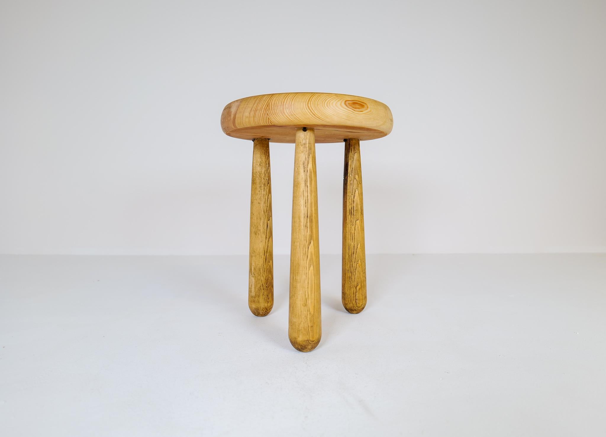 Sculptural stool in solid pine with complexity in the different colors of the wood.
This stool is a good example of the good craftsmanship and minimalistic stile to come in Scandinavian furniture. 

Good original condition with a beautiful patina