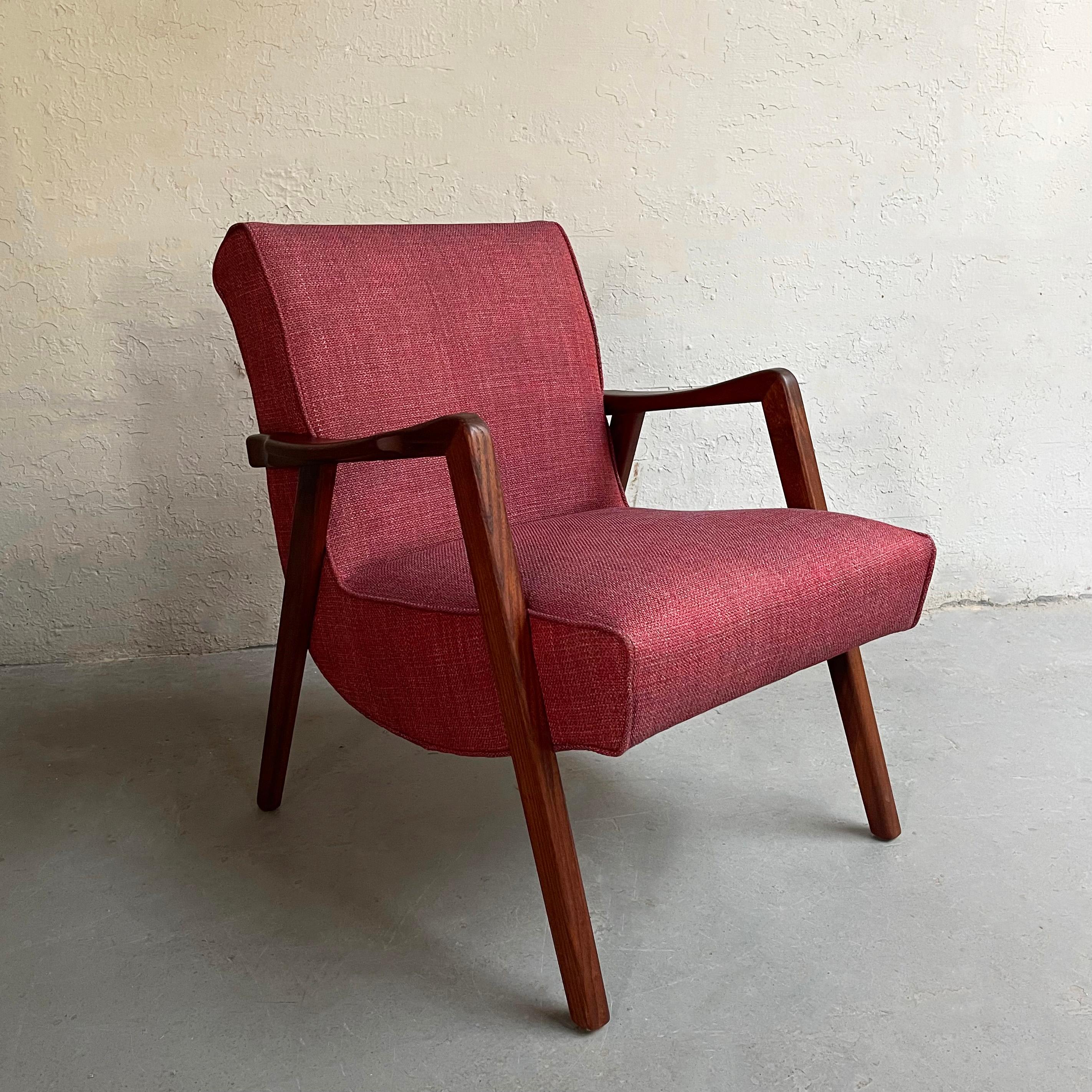Scandinavian modern armchair features a sculptural walnut frame with scoop seat newly upholstered in raspberry tweed.