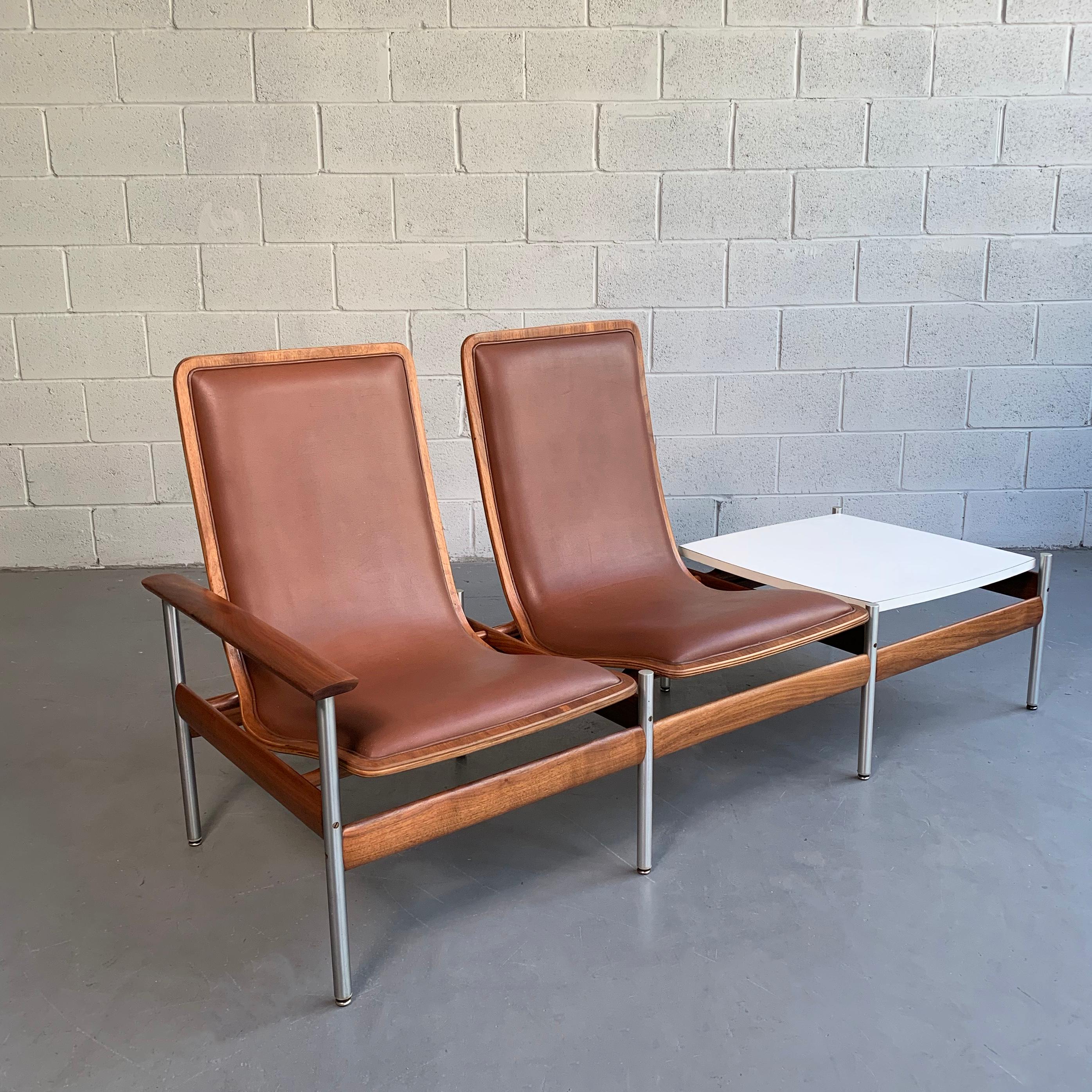 Scandinavian Modern, two-seat with side table ensemble designed in 1959 by Sven Ivar Dysthe for Fjord Fiesta, Norway features a tubular steel and walnut frame with vinyl upholstery and white formica tabletop. Table is 14 inches height.