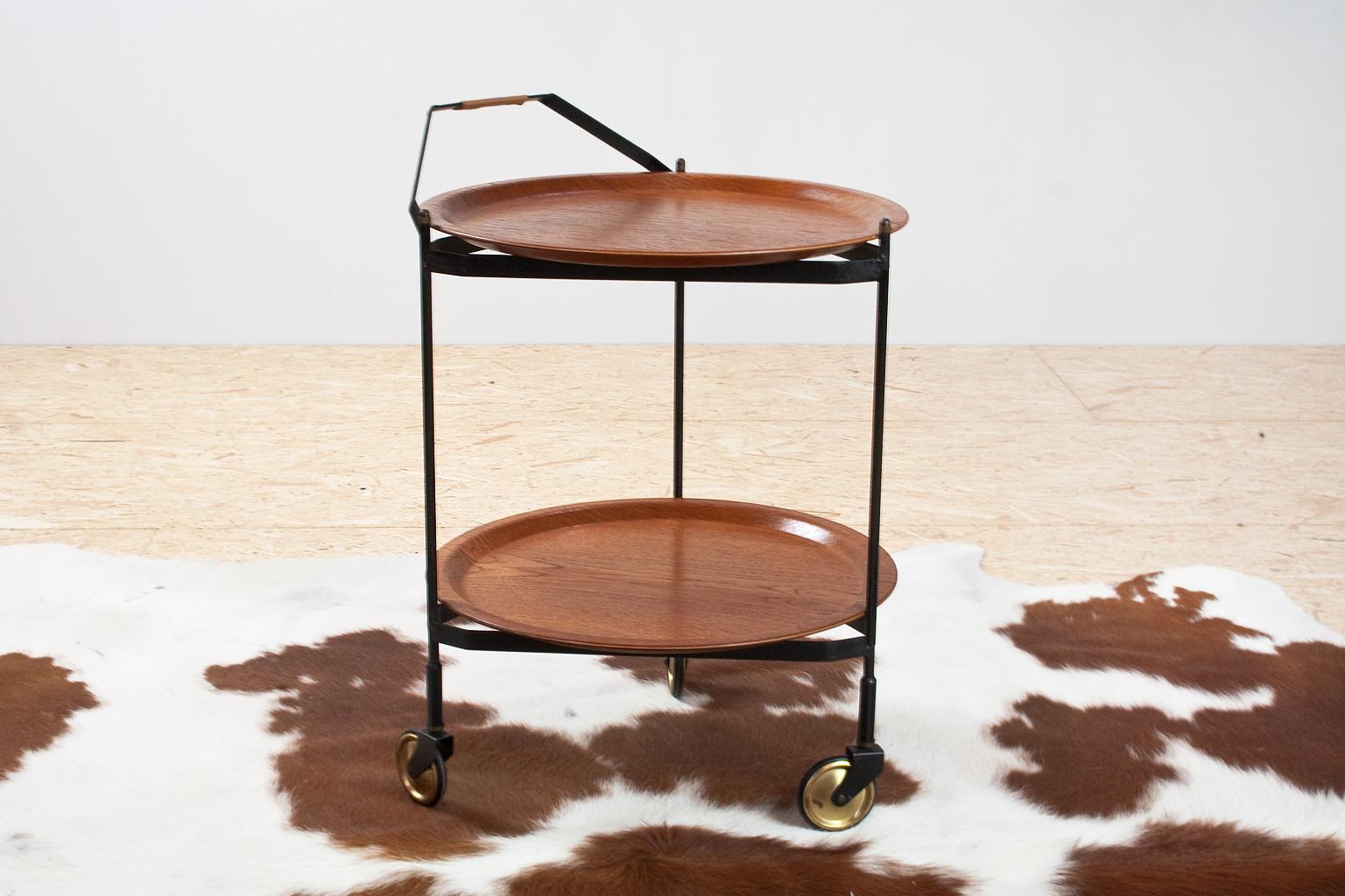 Elegant serving chart or trolley in black metal and teak wooden trays, Scandinavian Modern 1960s.
The teak trays are in excellent condition, the frame is foldable and intact, with some traces conform age, as shown on photo. Lovely side table for