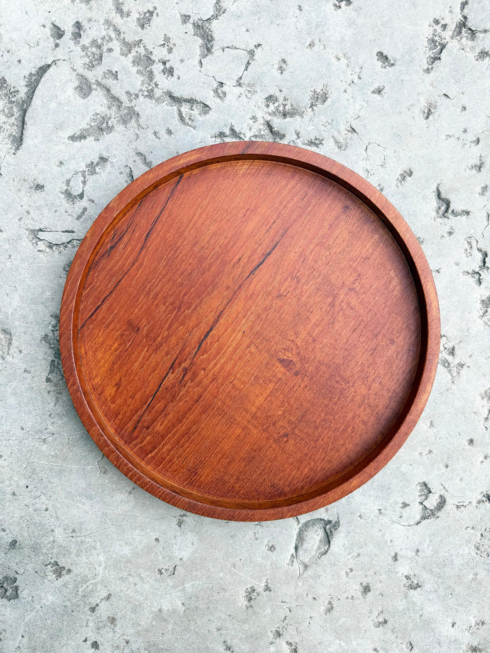 Scandinavian Modern serving tray in teak, Karl Holmberg i Götene, ca 1950-60s.
Wear and patina consistent with age and use. 
Light water ring marks, as seen on the last picture.
Scuff on the back, as seen on the picture.