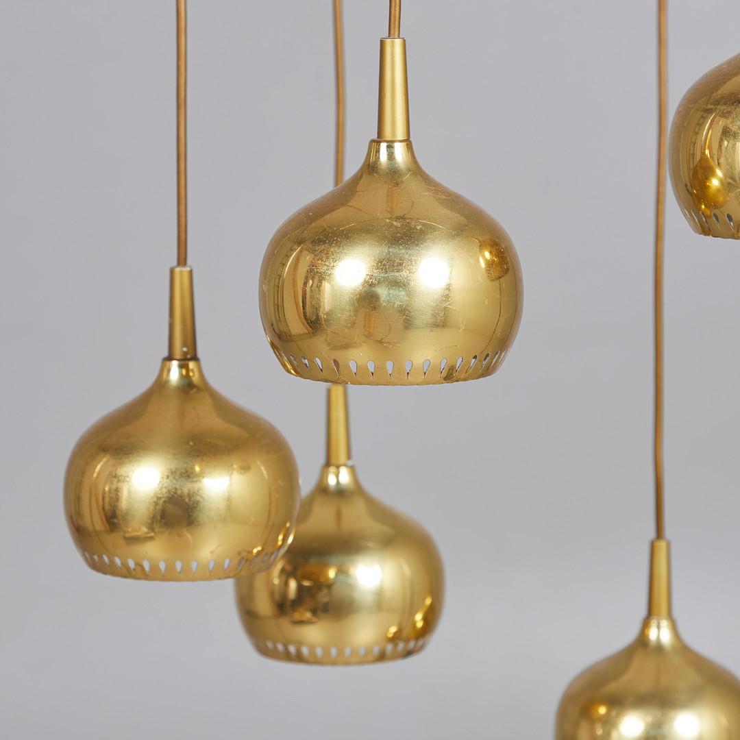 Set of 6 perforated brass lamps. Total dimensions hung: H.140cm, D.40cm

Active between the 1950s and '70s—in the golden age of Scandinavian design—Swedish interior decorator and furniture designer Hans-Agne Jakobsson (1919-2009) is best