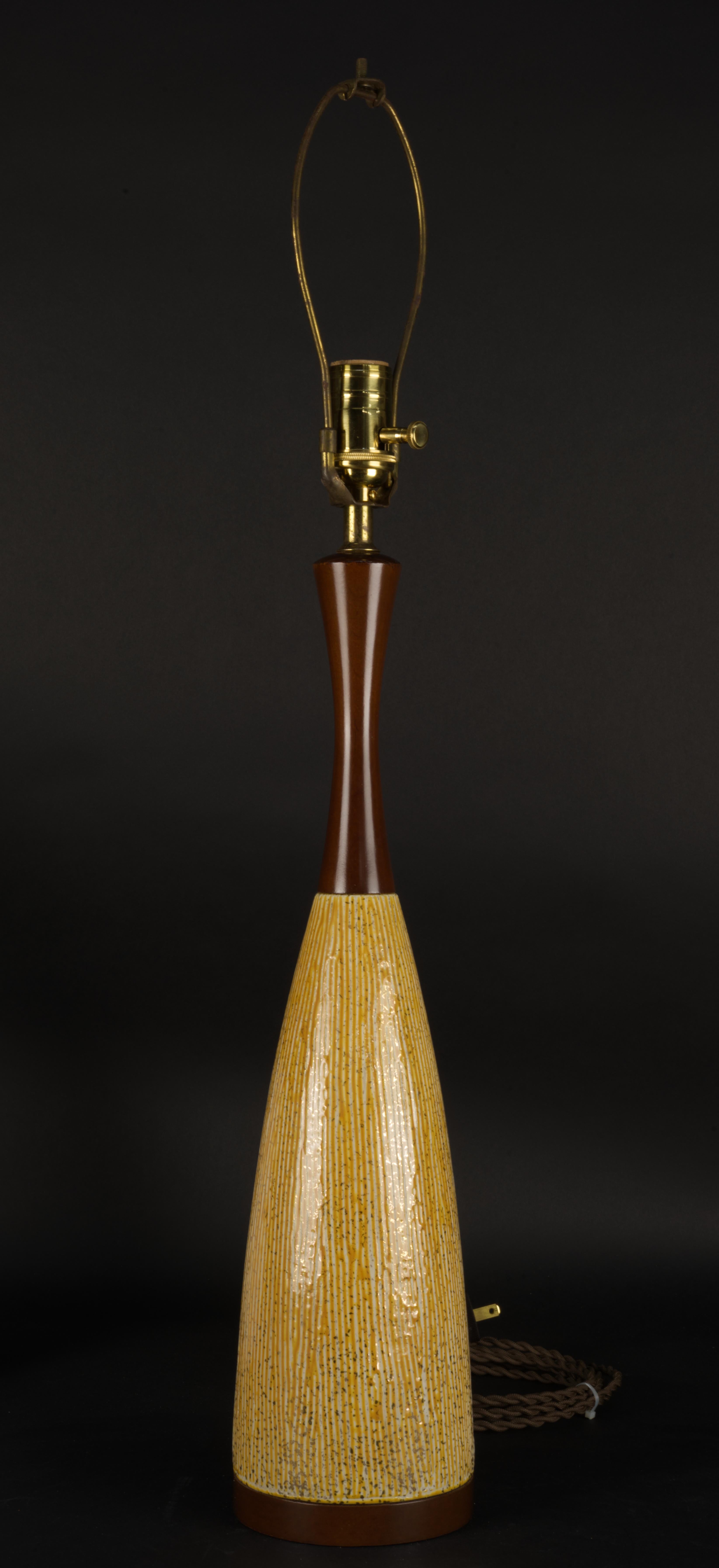  Magnifique lampe vintage du milieu du siècle dernier, de style organique scandinave, avec un design sgraffite de rayures verticales sur un glaçage jaune chaud et de petites paillettes d'or sur tout le corps, avec une base et un col en bois de hêtre