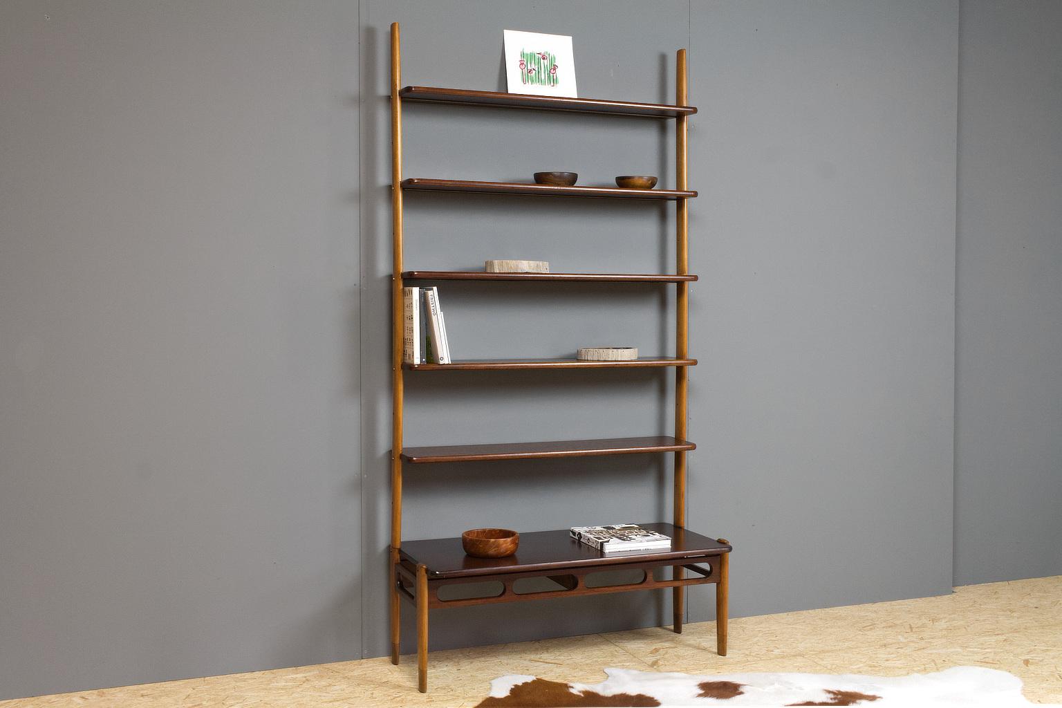 A great shelving unit designed by William Watting for A/S Mikael Laursen Århus, Denmark, 1950s-1960s. This transparent storage unit is made of solid teak shelves and oak uprights. It consists of a free standing bottom shelf and wall-mounted top