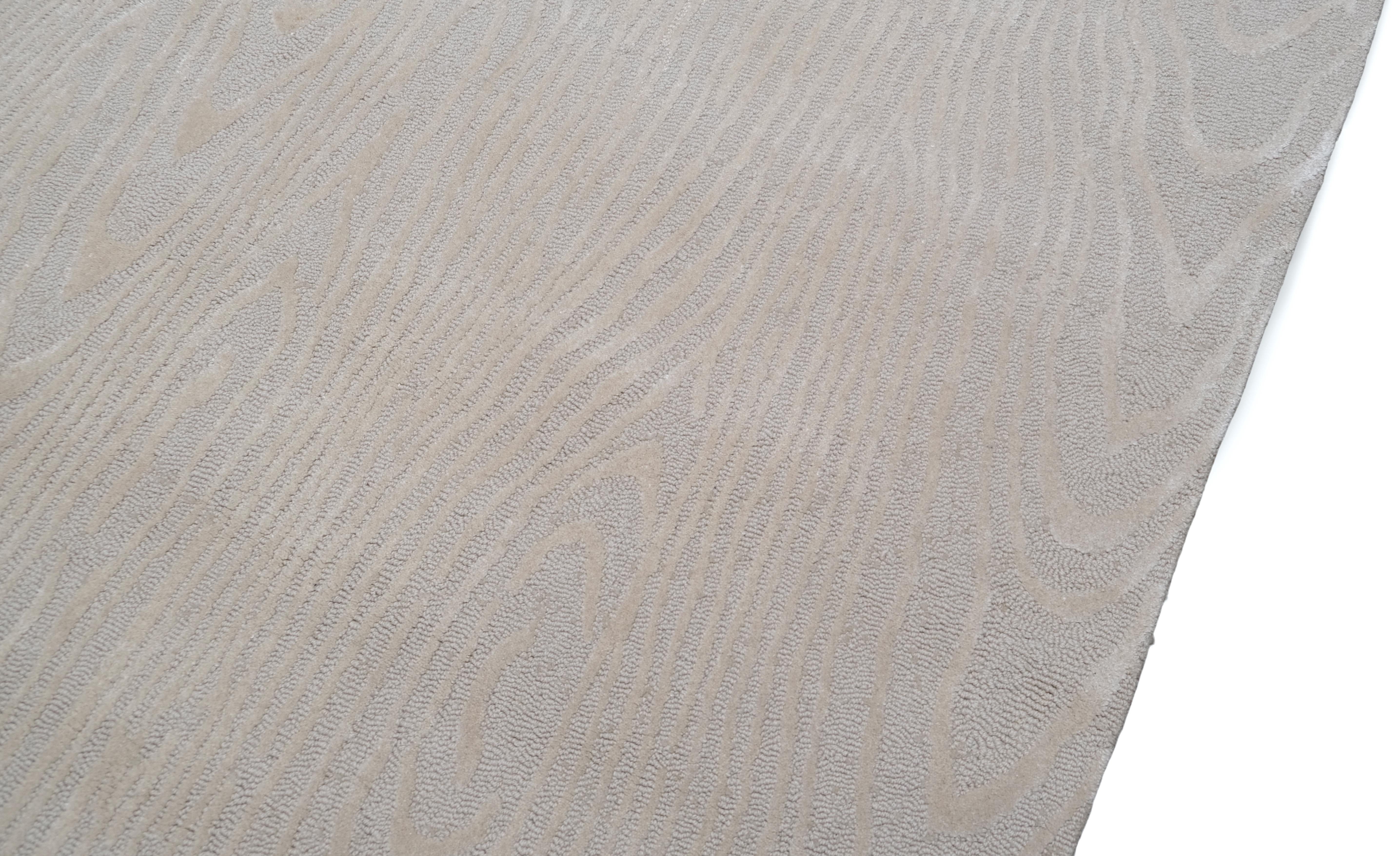 Verschönern Sie Ihren Raum mit der raffinierten Eleganz dieses handgefertigten Wollteppichs, der ein dezentes, von der Holzmaserung inspiriertes Muster in weichen, neutralen Tönen aufweist. Dieses luxuriöse Möbelstück verbindet mühelos modernen