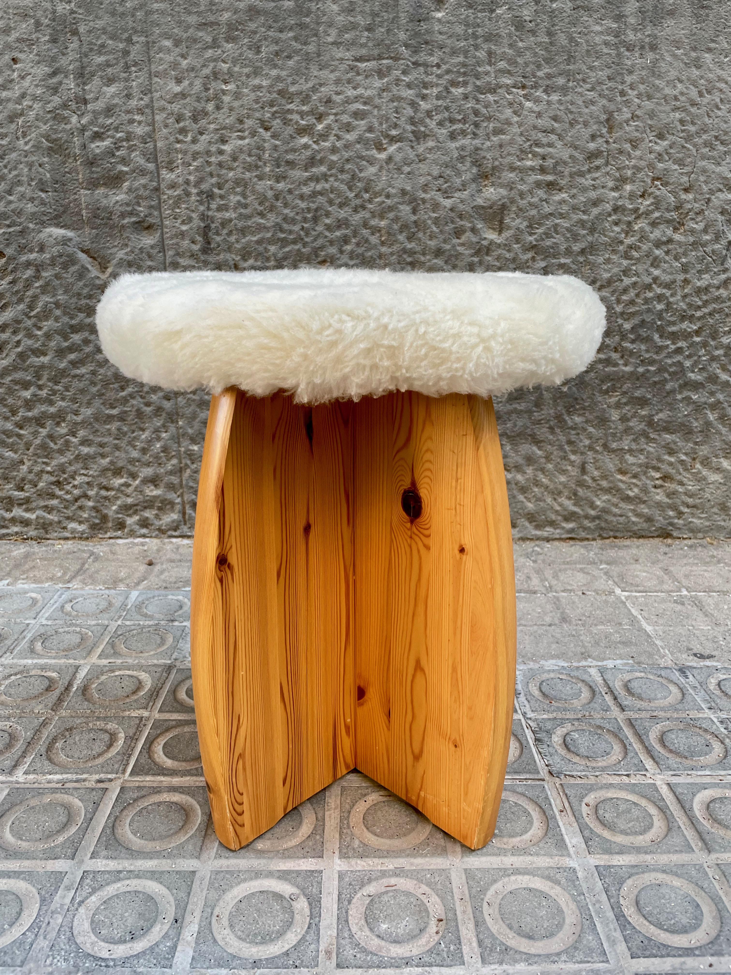 Solid pine stool upholstered in sheepskin, manufactured in the 1970s. In the style of Roland Wilhelmsson, Gilbert Marklund, Yngve Ekström, Axel Einar Hjorth etc.