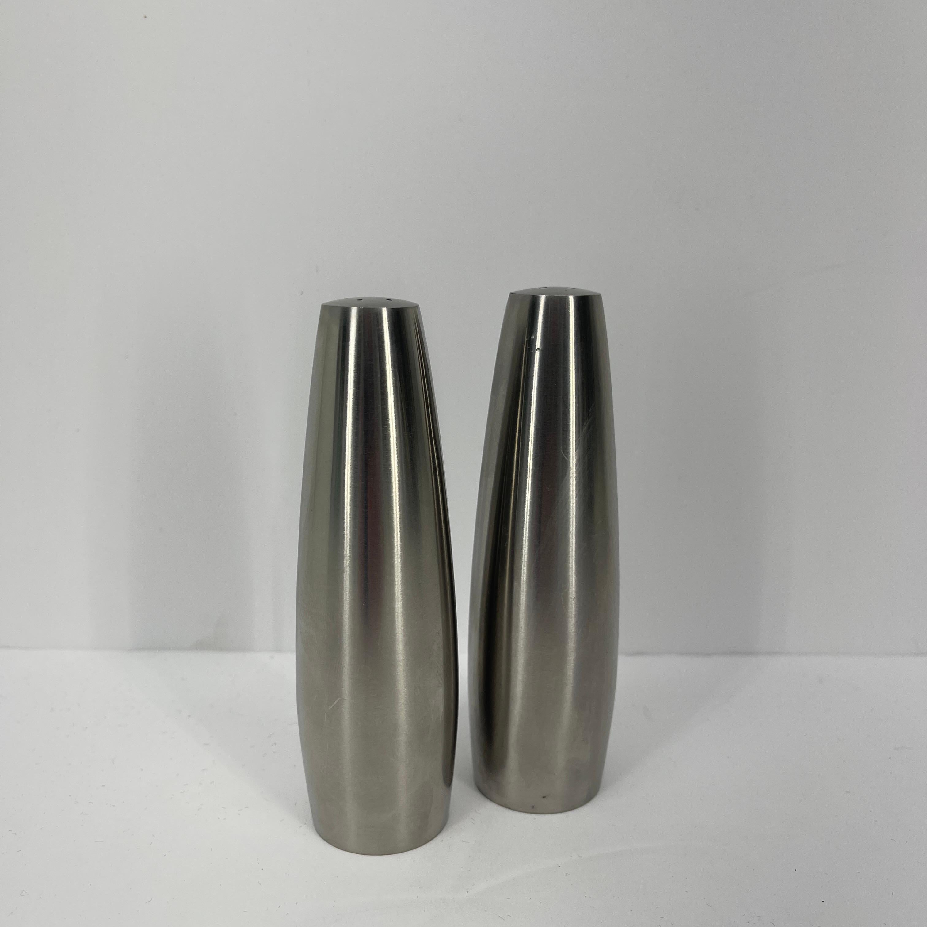 Mid-Century Modern Danish pair of salt and pepper shakers by Jens Harald Quistgaard for Dansk, circa 1970's. The Minimalist shakers feature a tapered cylindrical form in brushed stainless steel. The set is a classic Danish design; they look like