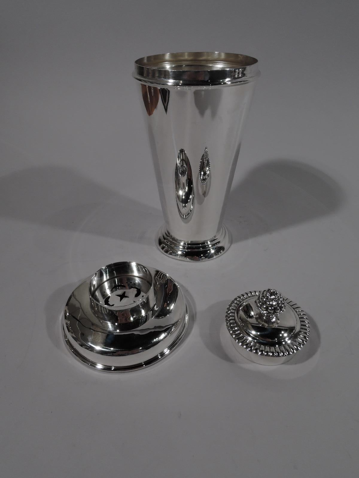 Scandinavian Modern sterling silver cocktail Shaker. Made by Kristian M. Hestenes in Bergen, Norway, circa 1950. Straight and tapering cup on spread and stepped foot. Detachable top with curved shoulder and short neck with built-in strainer. Cover
