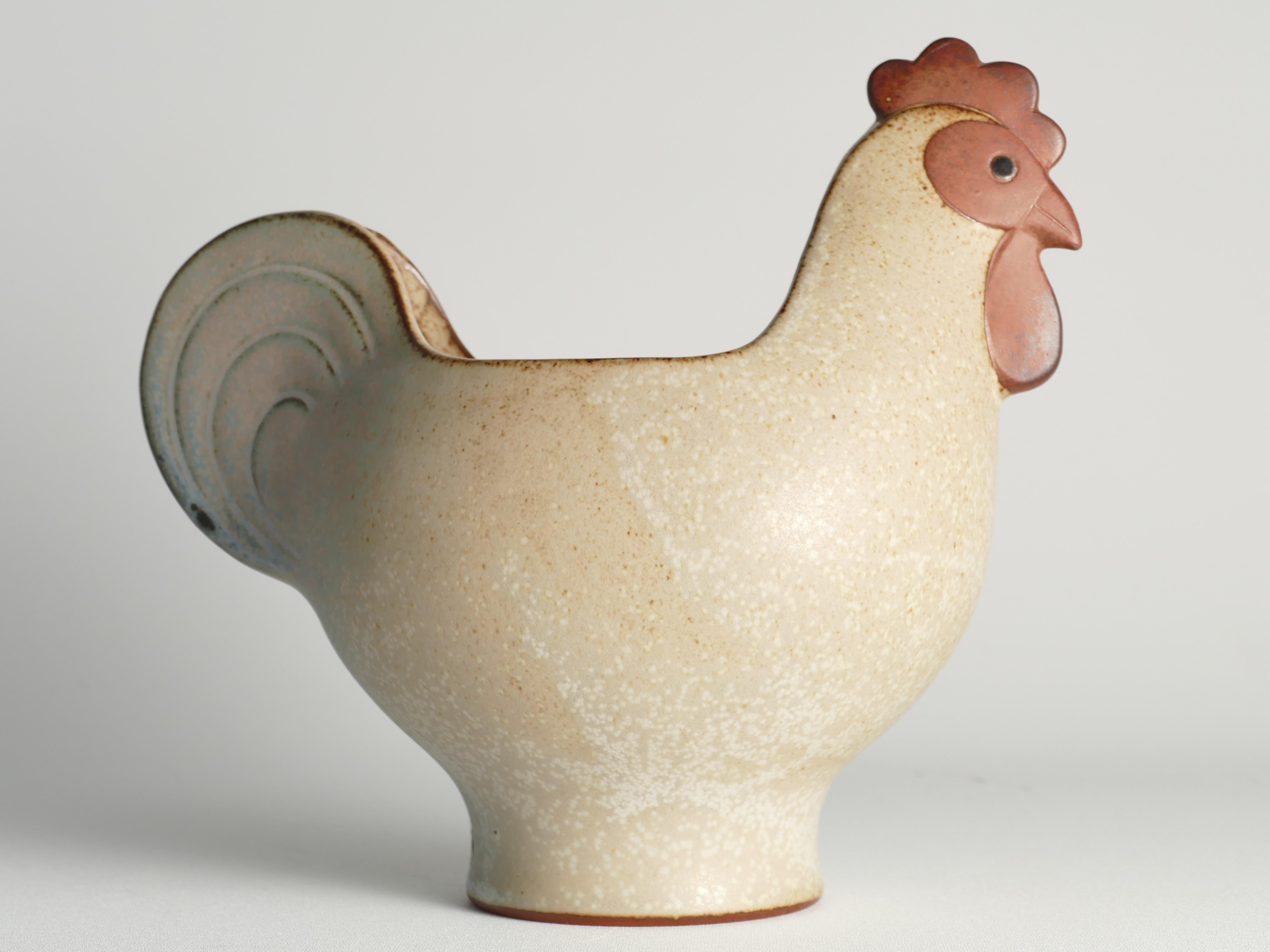 This stoneware hen bowl, adorned with a mottled brown glaze and designed by Lisa Larson, is a part of the Påsk (Easter) series. The hen bowl serves a versatile purpose, whether for presenting eggs, candy, or simply as a decorative piece.

Lisa