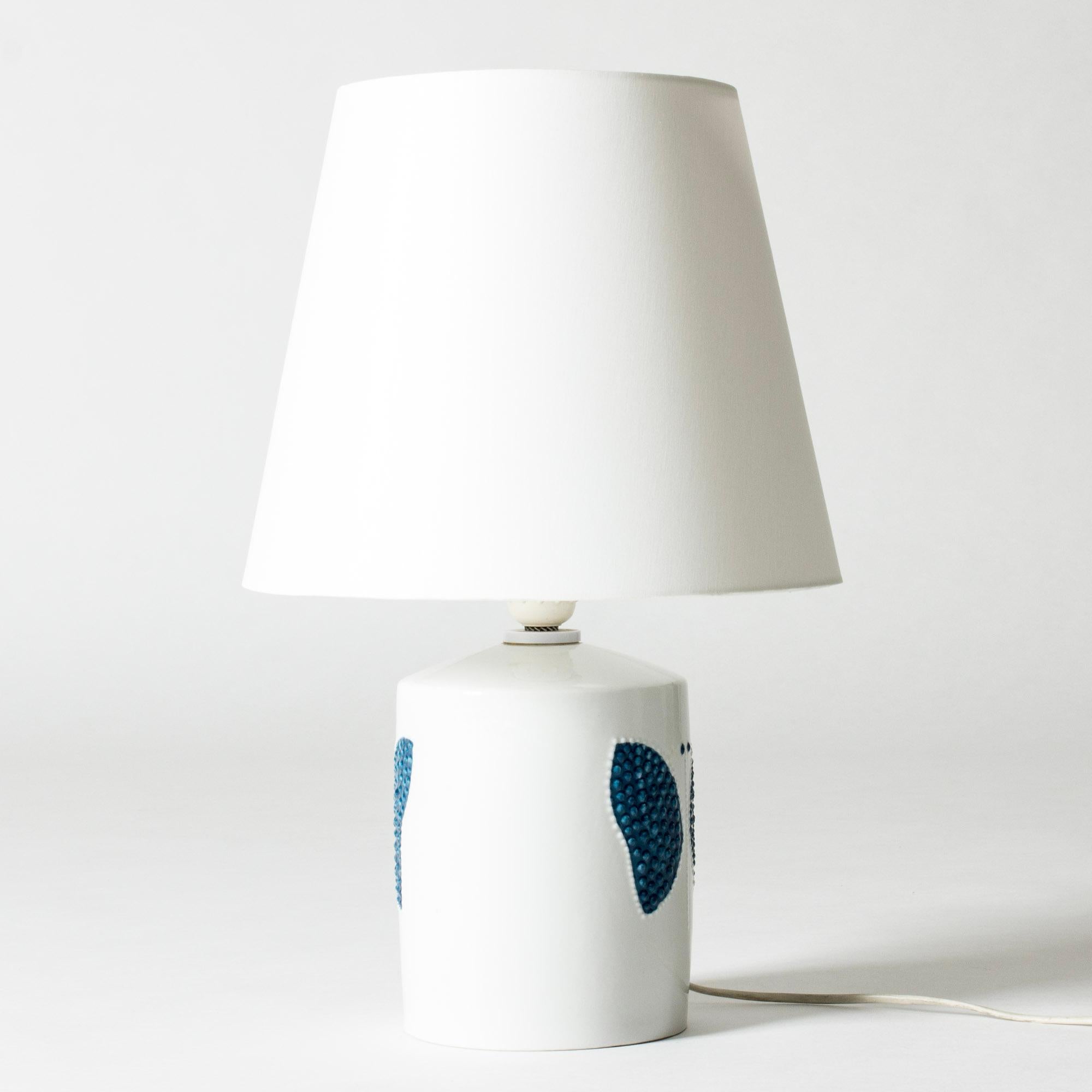 Hübsche Tischlampe aus Steingut von Sylvia Leuchovius, weiß glasiert mit einem stilisierten Schmetterling im Relief.