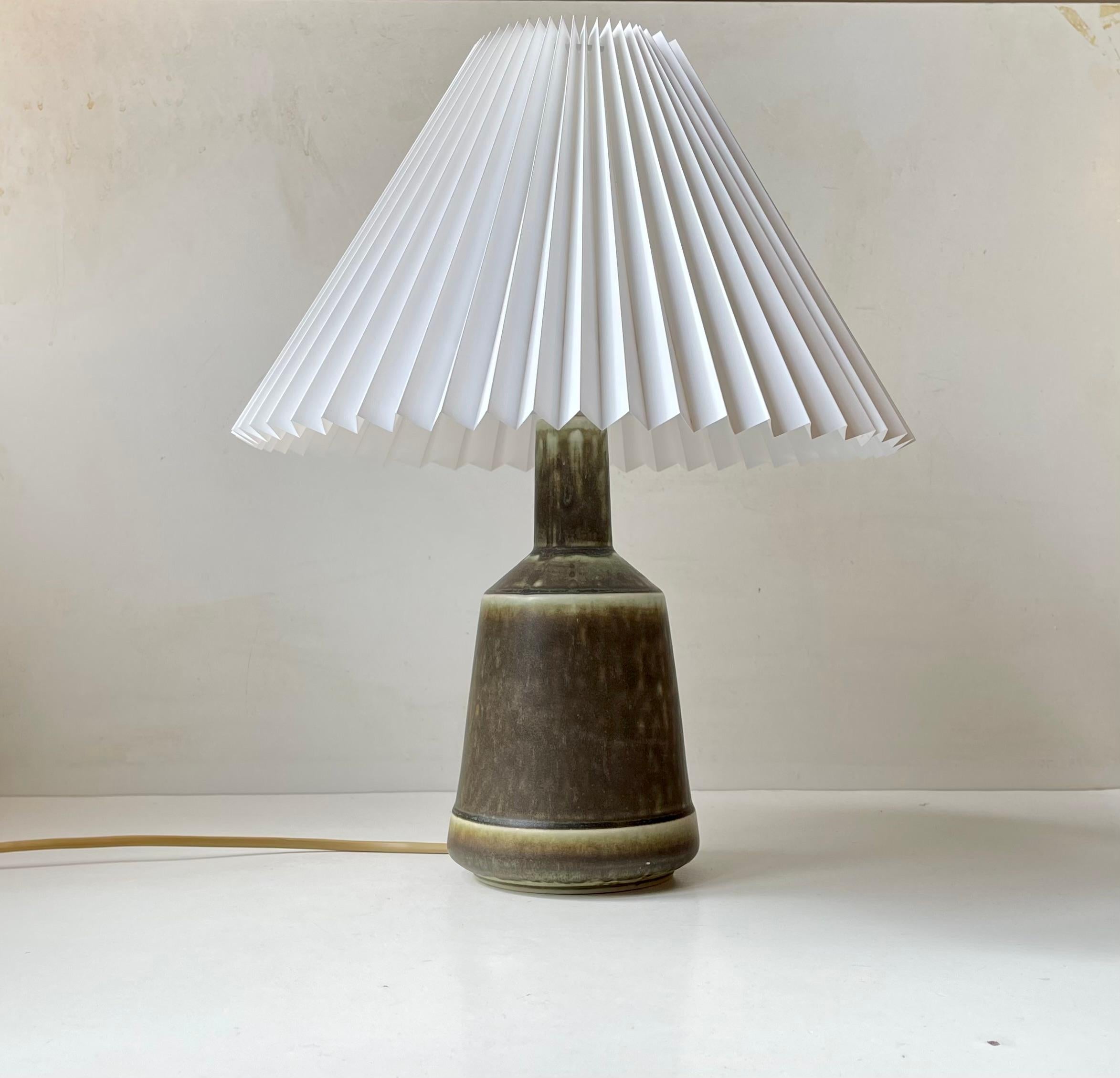 Exceptional stoneware table light from Danish Desiree Stentøj. It features a dusty hares-fur type olive green glaze that changes to a lighter delicate tone towards the edges. It original white socket has a pin on/of switch that hides just above the