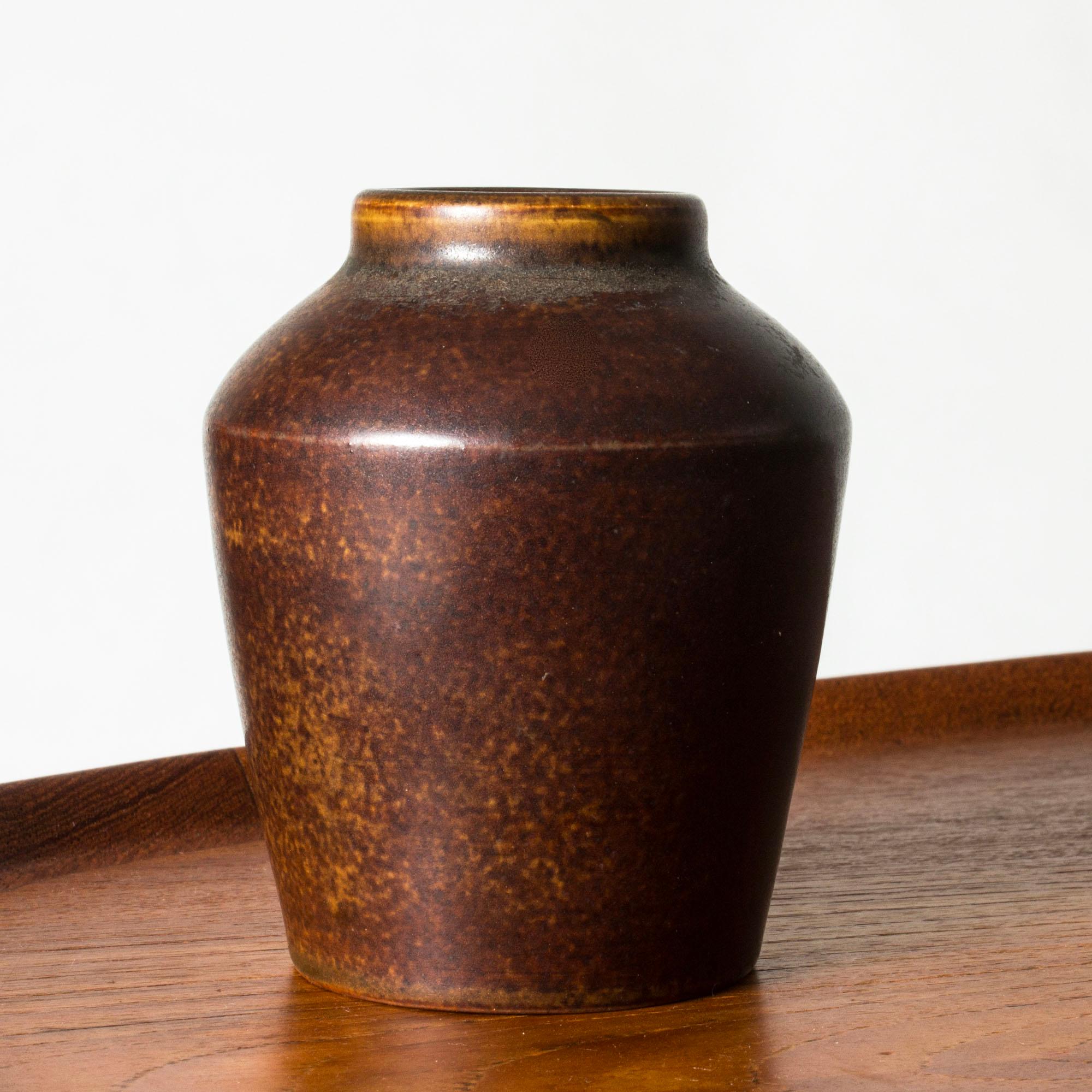 Small stoneware vase by Eric and Ingrid Triller, with a wide mouth and warm brown and terracotta colored glaze.

Fleeing World War II, German potters Eric and Ingrid Triller settled in the industrial village Tobo and started making their Bauhaus